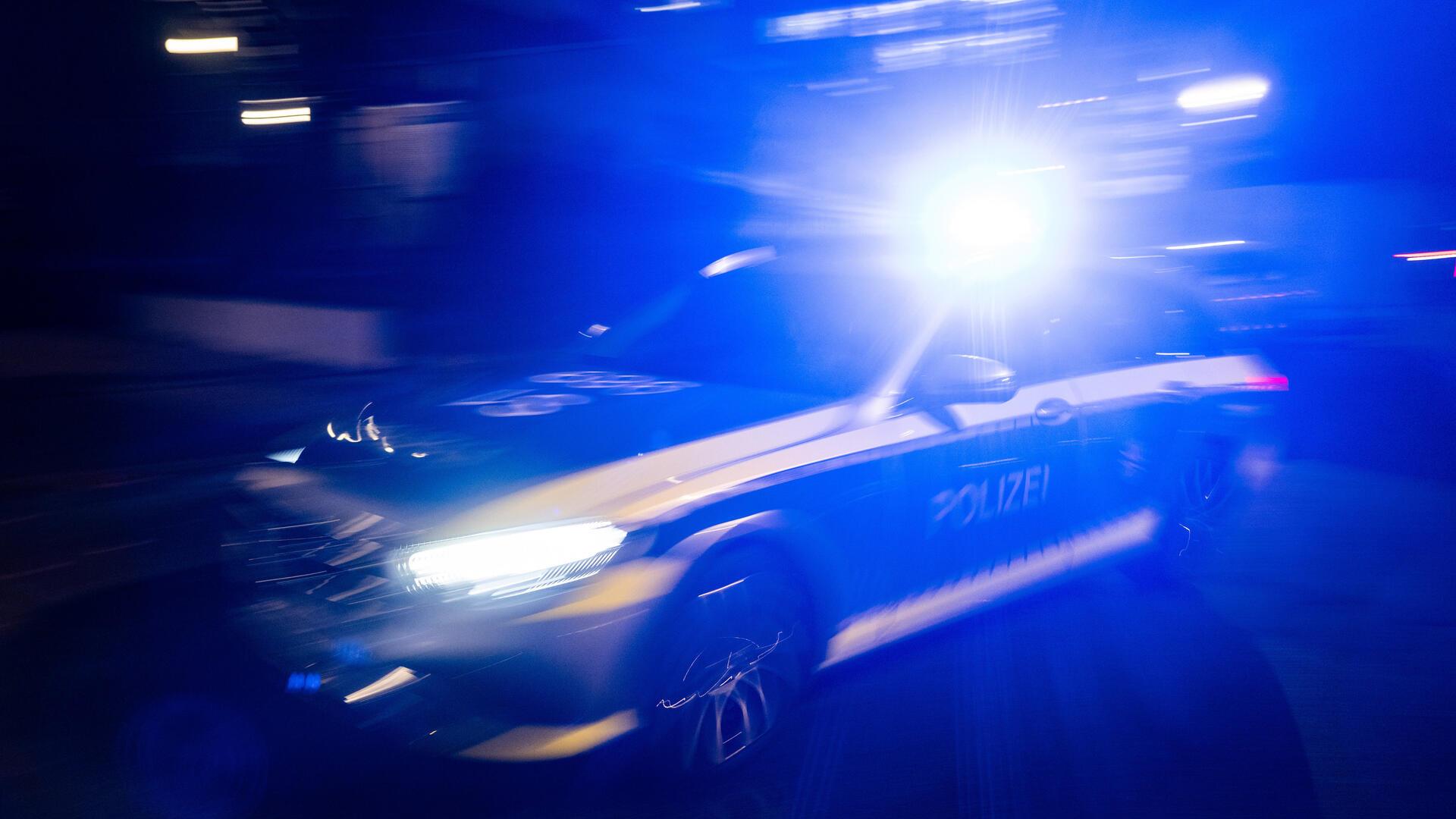 ILLUSTRATION - 30.11.2023, Baden-Württemberg, Stuttgart: Ein Polizeifahrzeug fährt im Rahmen eines Fototermins mit Blaulicht an einem Gebäude vorbei (gestellte Szene, Langzeitblichtung mit Wischeffekt). (zu dpa: «Verfolgungsfahrt mit Polizei - mutmaßlicher Fahrer betrunken») Foto: Marijan Murat/dpa +++ dpa-Bildfunk +++