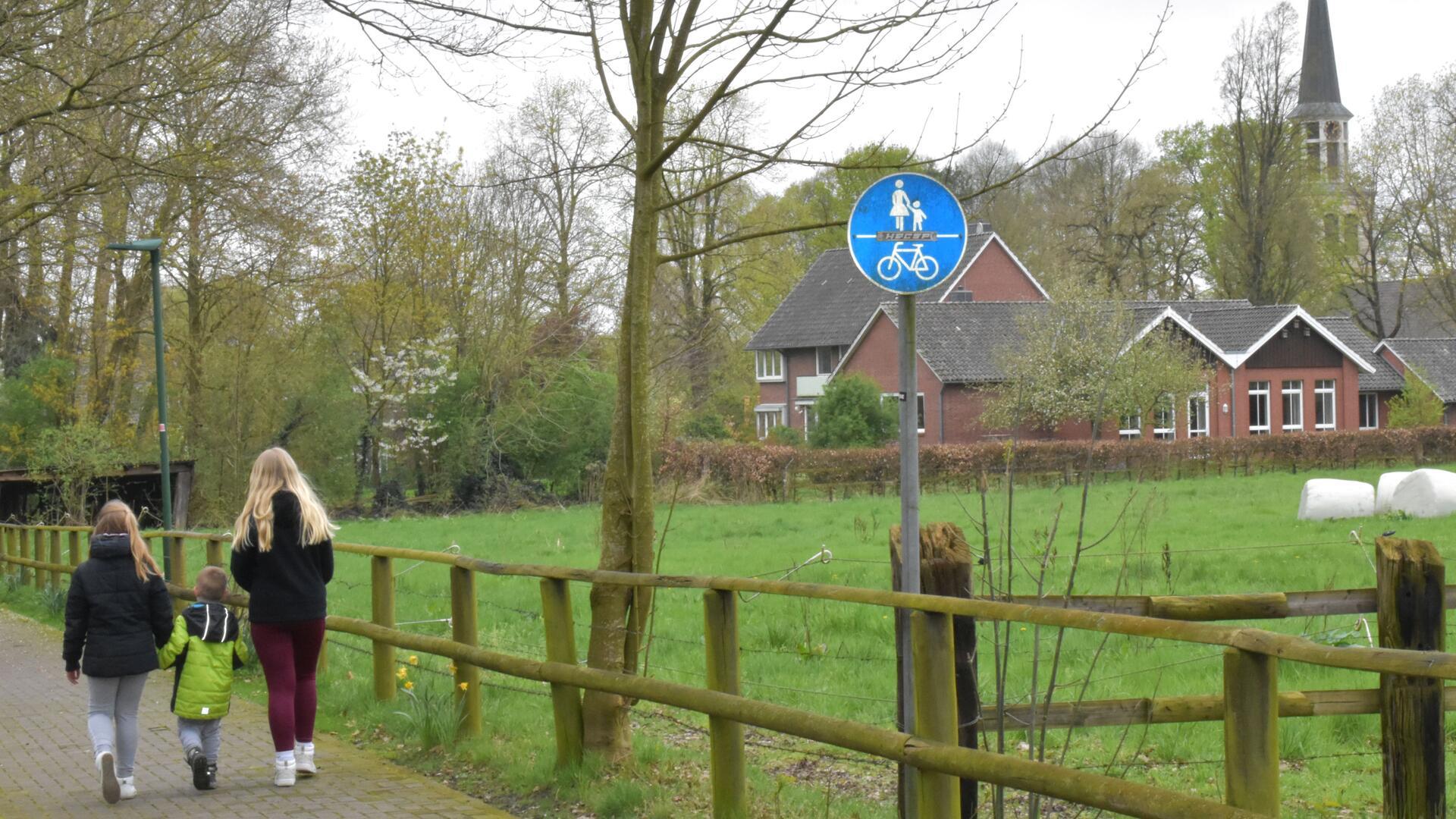 drei Kinder gehen auf einem Fußweg