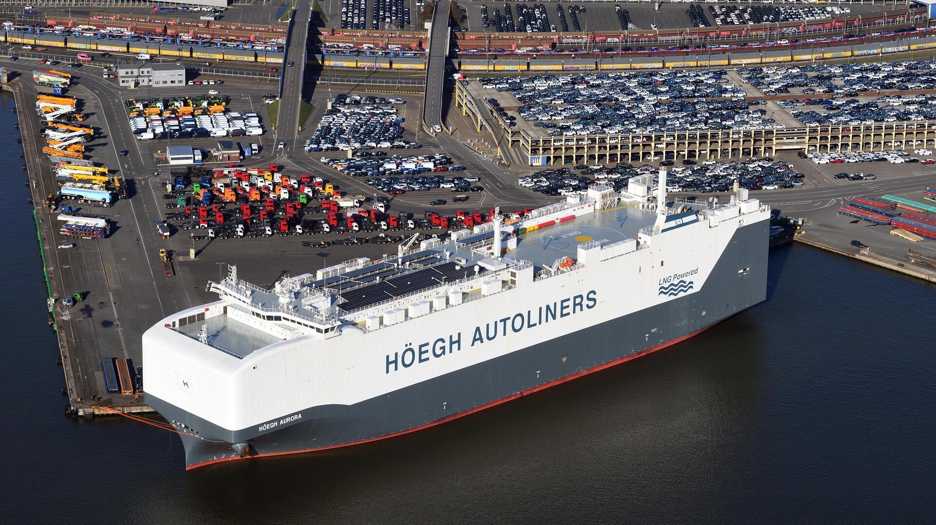 Autotransporter im Bremerhavener Hafen. Auf der Seite steht groß der Name der Reederei "Höegh Autoliners".