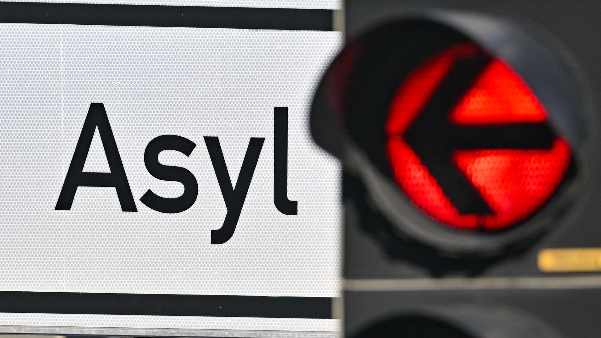 Schild mit Aufschrift „Asyl“ neben einer Ampel