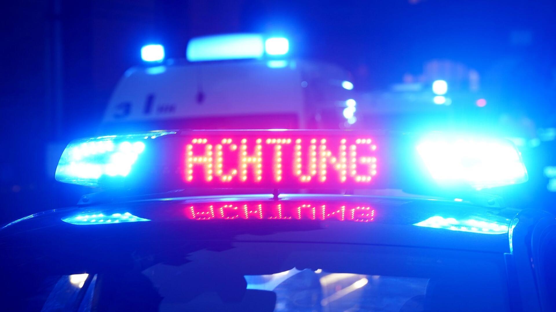 „Achtung“ ist auf dem Dach eines Polizeiautos zu lesen.