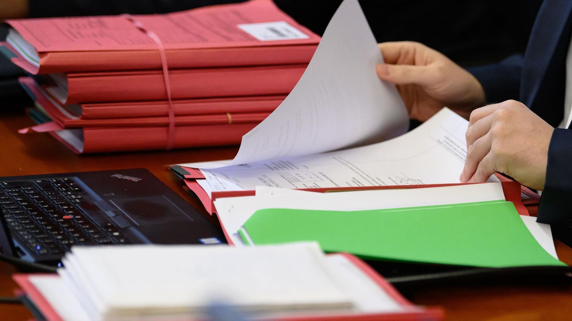 Akten liegen zum Prozessauftakt im Landgericht auf einem Tisch.