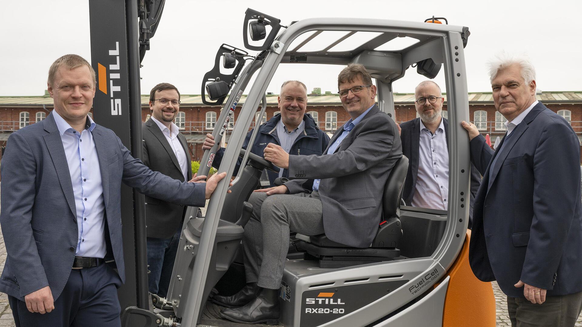 Akteure der Klimakooperation Fischereihafen (CCF) mit einem wasserstoffbetriebenem Stapler (von links): Timo Mahler (Deutsche See), Dr. Alexander David (FBG), Ralf Finck (Frosta), Peter Jetz (Norddeutsche Solar Ceramics), Olaf Schröder (FBG) und Prof. Dr. Gerhard Schories (ttz).