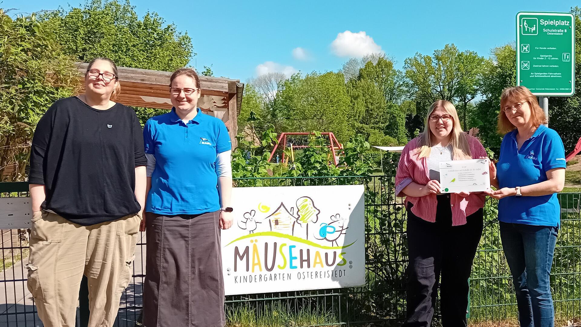 Alexandra Schiefke (links) und Damaris Zipkat (Zweite von links) bieten im Kindergarten „Mäusehaus“ in Ostereistedt regelmäßig die Nabu-AG an. Kita-Leiterin Eva Holsten nimmt das Zertifikat von Bettina Schroeder von der Umweltpyramide (rechts) freudig entgegen.