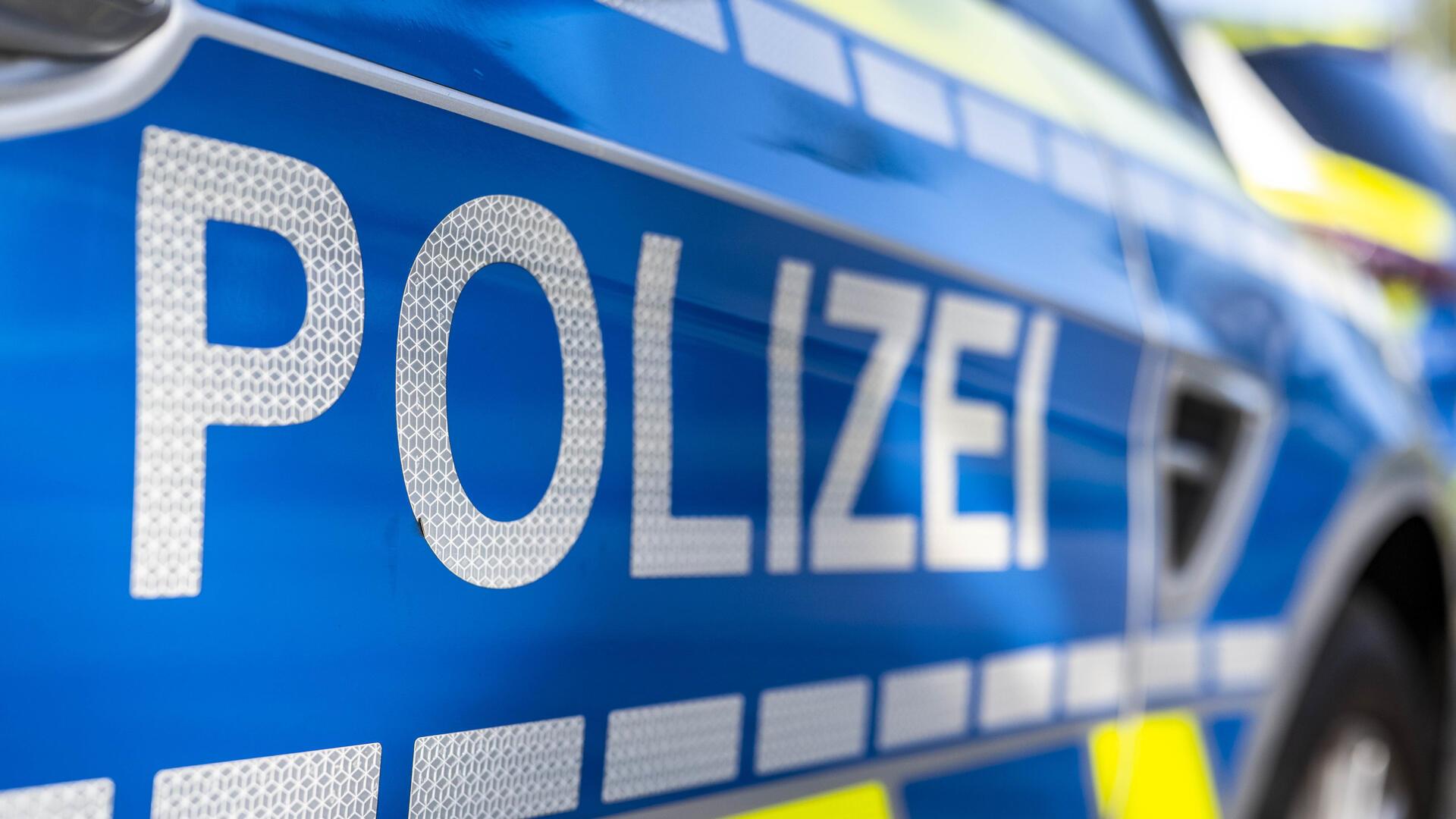 An der Tür von einem Streifenwagen steht der Schriftzug "Polizei".