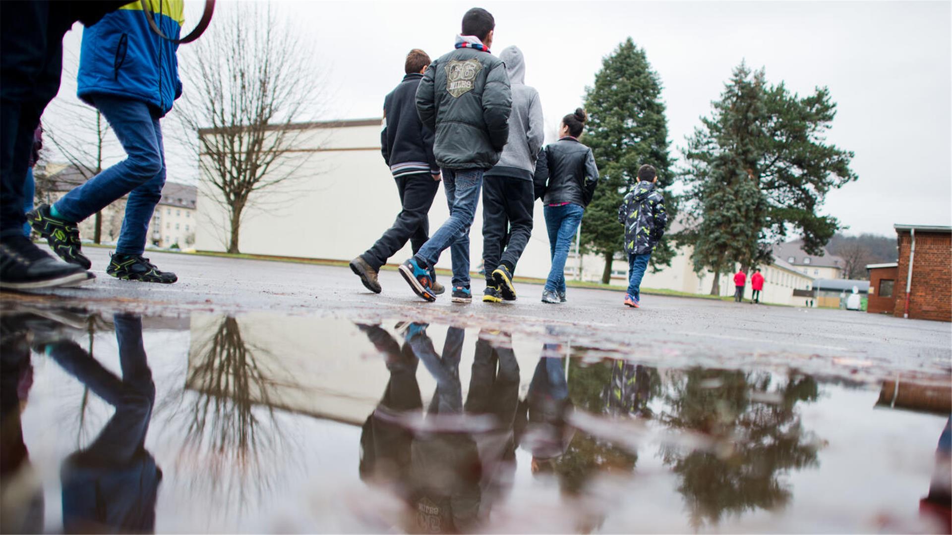 Junge Flüchtlinge laufen am 01.02.2016 über den Hof einer Erstaufnahmeeinrichtung für Flüchtlinge in Hameln (Niedersachsen)