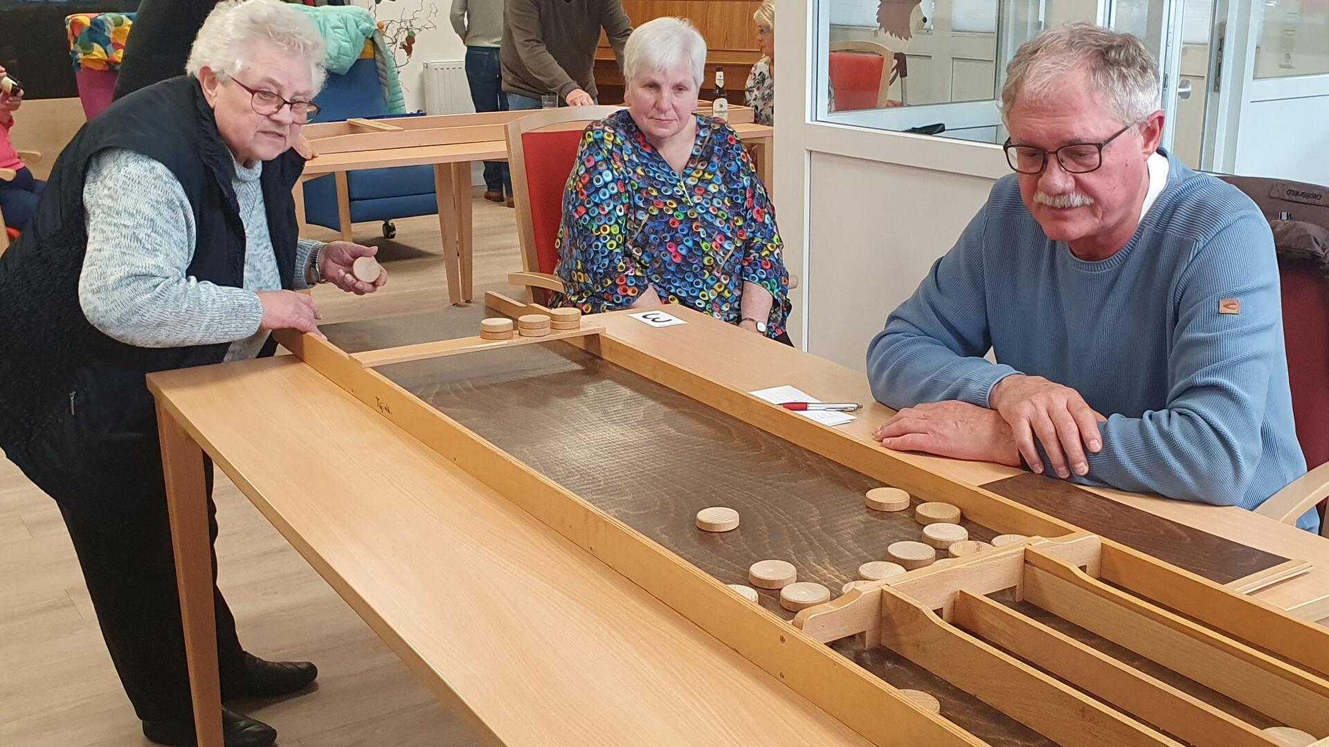 Das Foto zeigt Senioren beim Jakkolo spielen. 