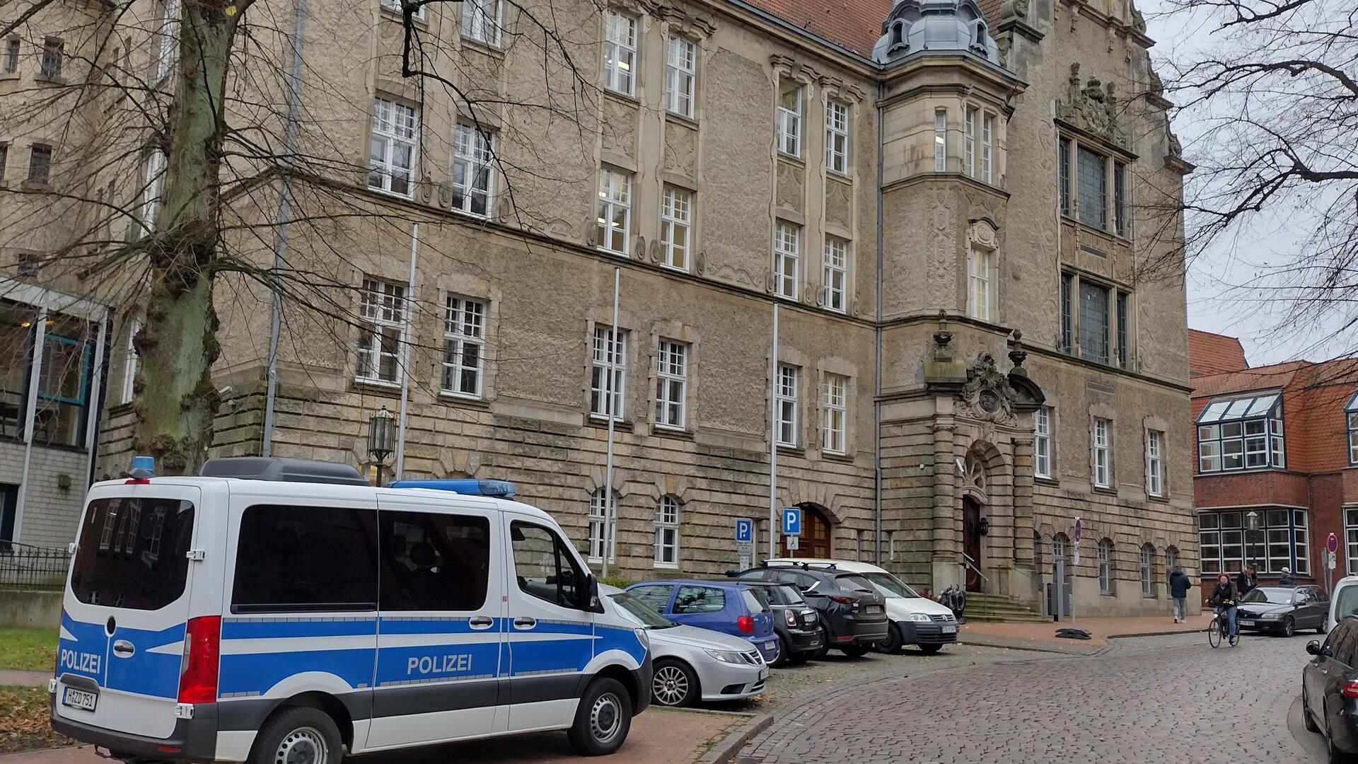 Ein Polizeibus und viele Autos parken vor dem Stader Landgericht.