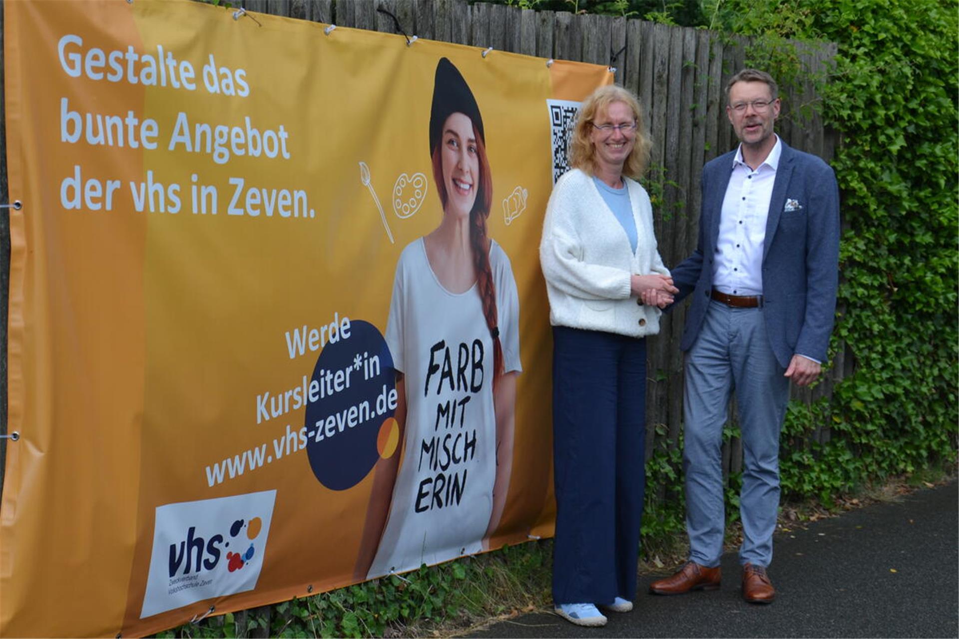 Andrea Stephan und Henning Fricke stehen vor einem Werbeplakat in Zeven