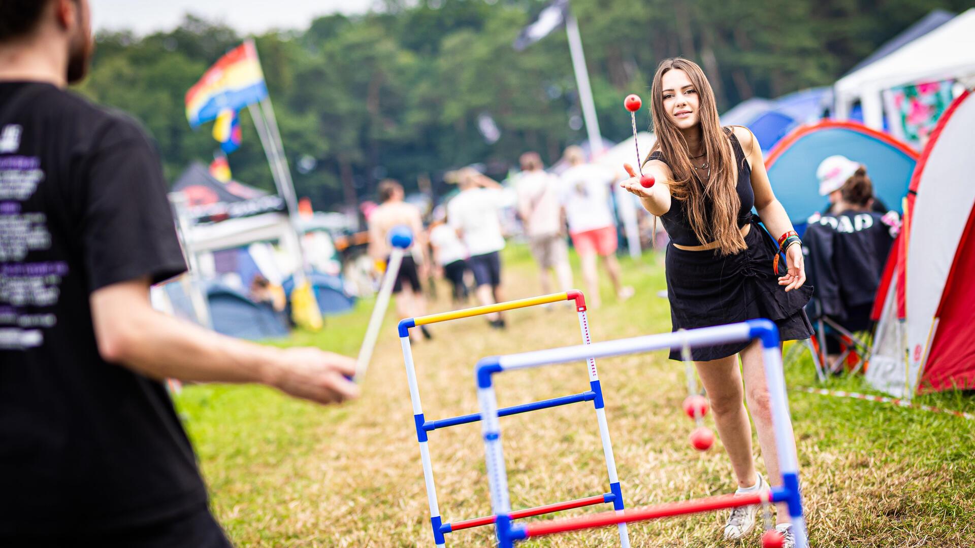 Anna (r) spielt auf dem Zeltplatz des Hurricane Festivals ein Wurfspiel.