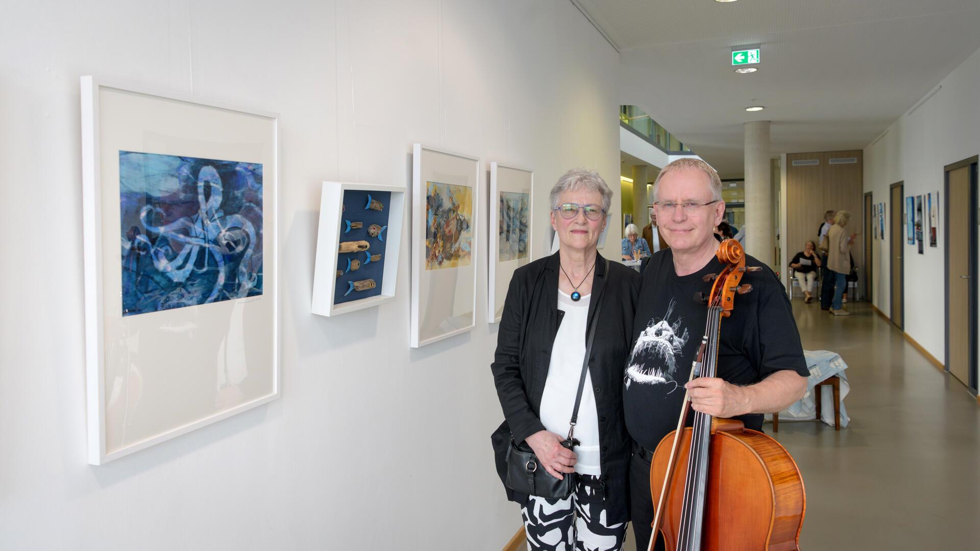 Kunstwerke an der Wand, Frau und Mann mit Instrument