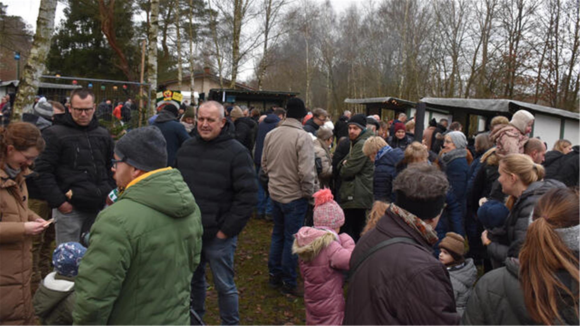 Besucher schlendern vorbei an Buden. 