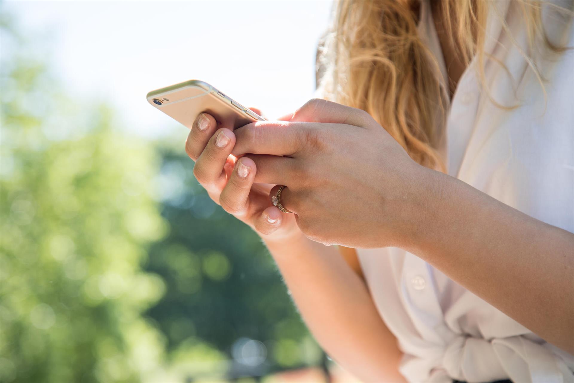 Eine Frau mit einem Smartphone in der Hand. 