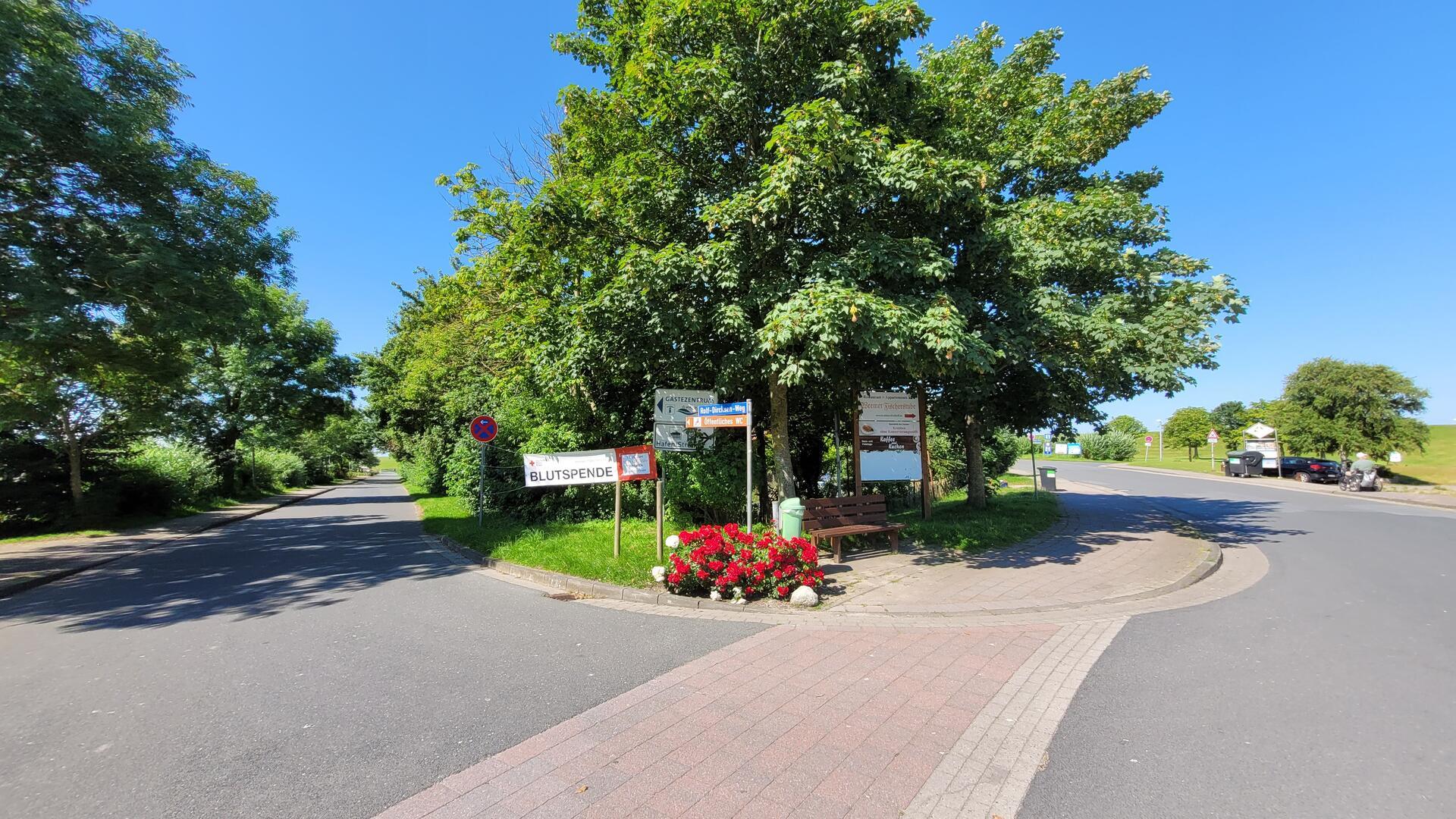 Auf der Strandstraße in Wremen: Links geht es zum großen Parkplatz am Gästezentrum. Rechts ist die Überfahrt zu Strand, Campingplatz und Kutterhafen.