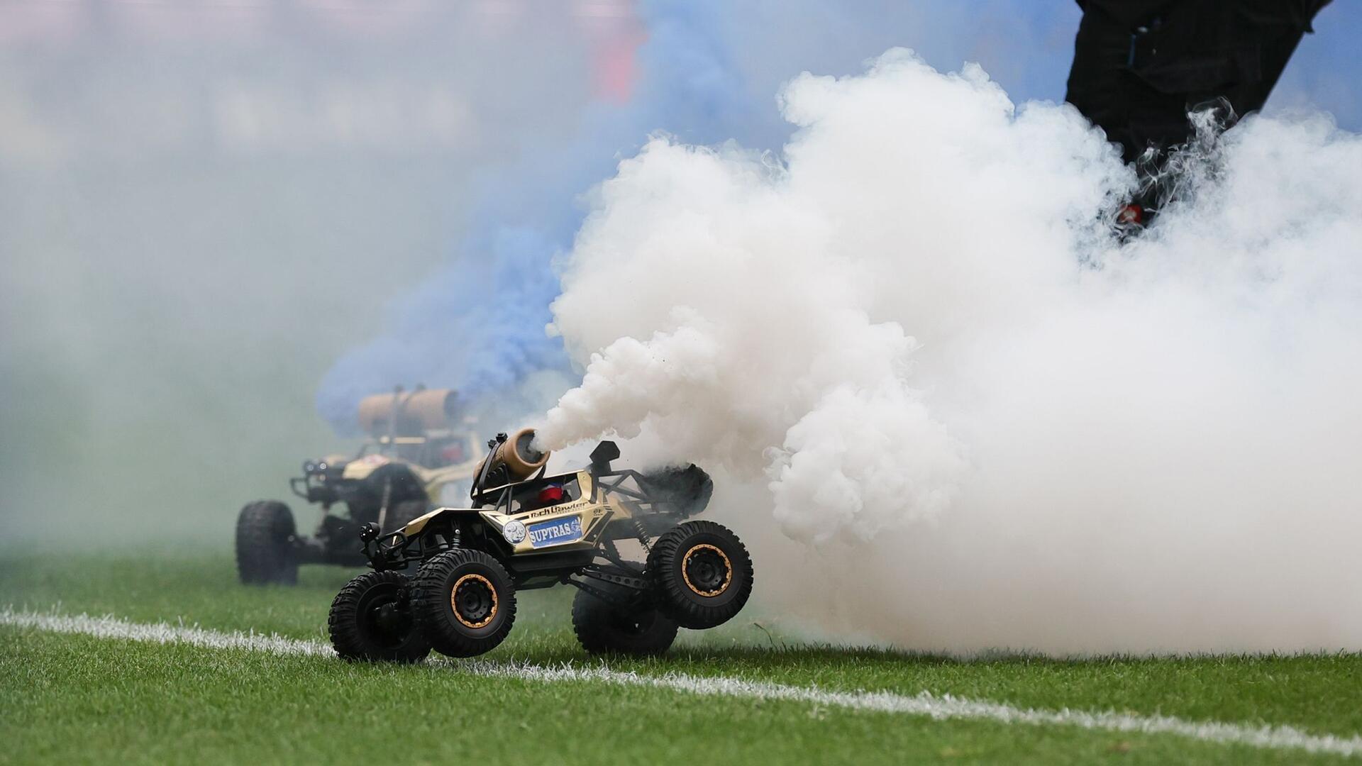 Aus Protest gegen den geplanten Investorendeal der Deutschen Fußball Liga haben Fans des FC Hansa Rostock ferngesteuerte Auto mit blau-weißen Rauchfackeln auf den Platz fahren lassen.