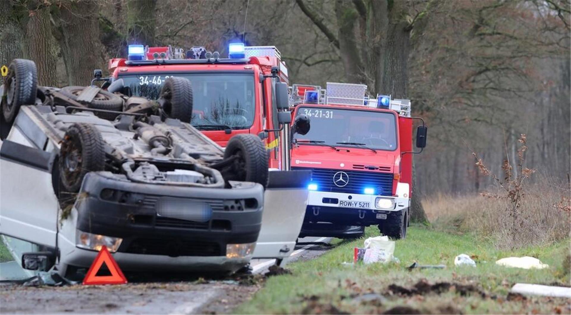 Zwei Feuerwehrwagen und ein beschädigter PKW, der auf dem Dach liegt.