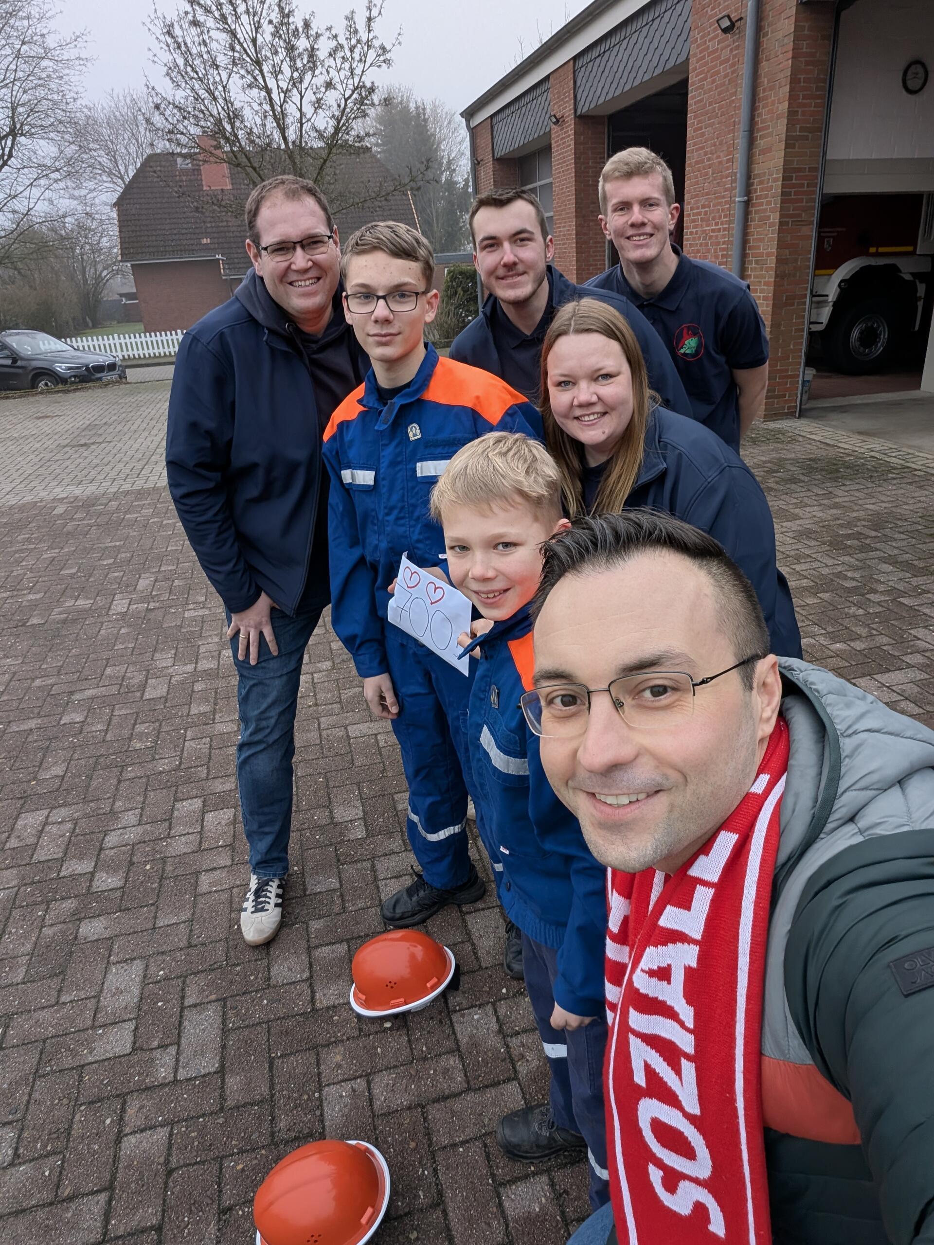 Mehrere Feuerwehrleute stellen sich zu einem Foto auf.