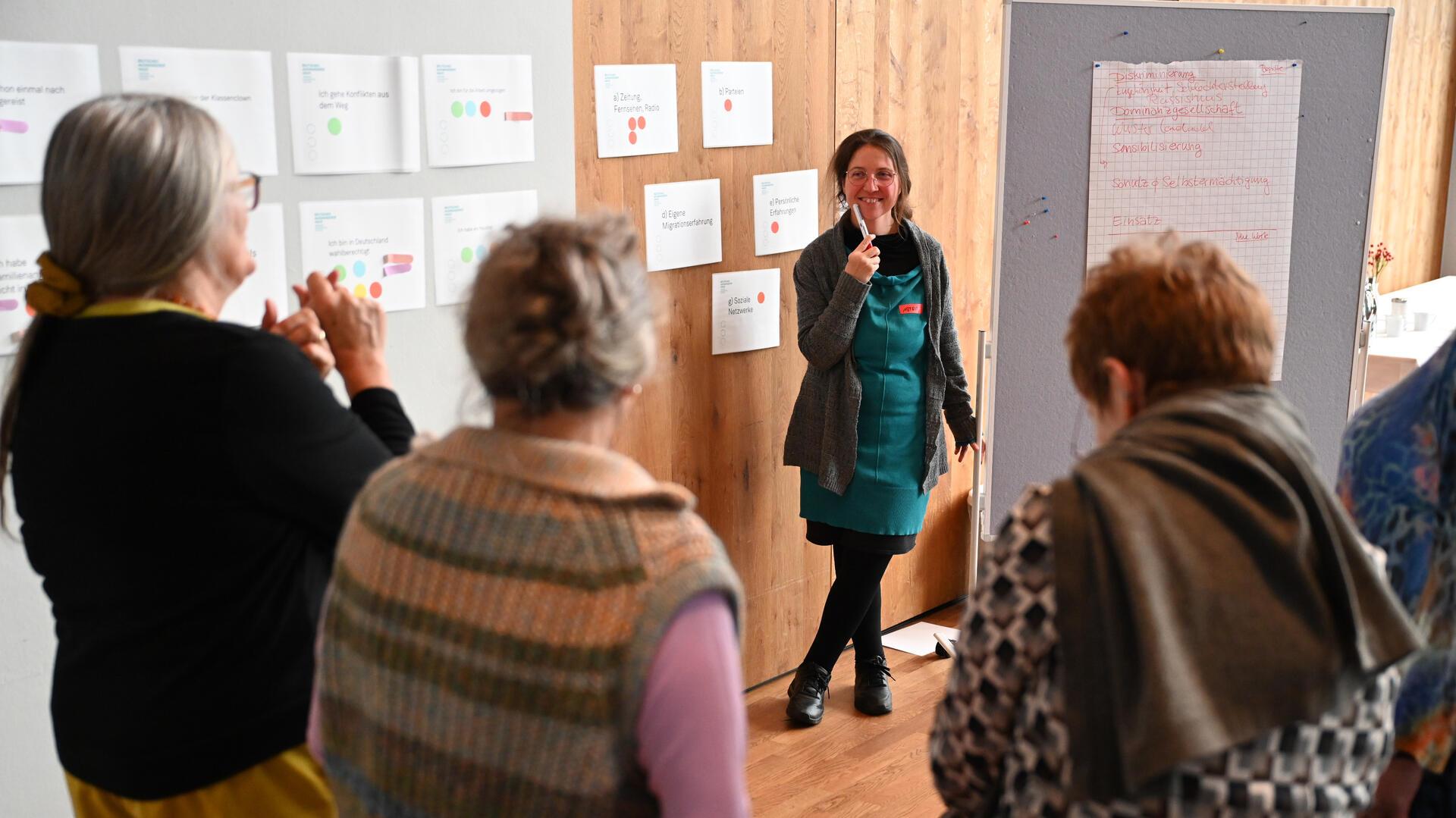 Eine Frau spricht bei einem Workshop mit weiteren Frauen