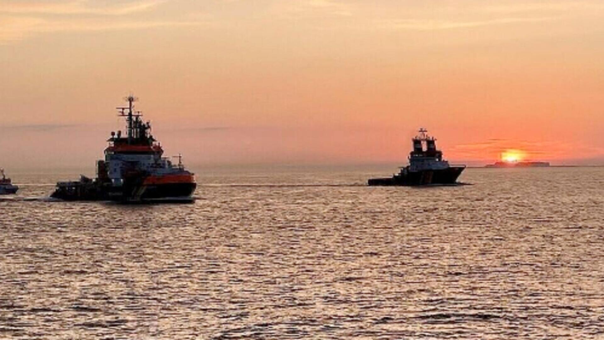 Mehrere Schiffe fahren bei Sonnenaufgang auf der Nordsee