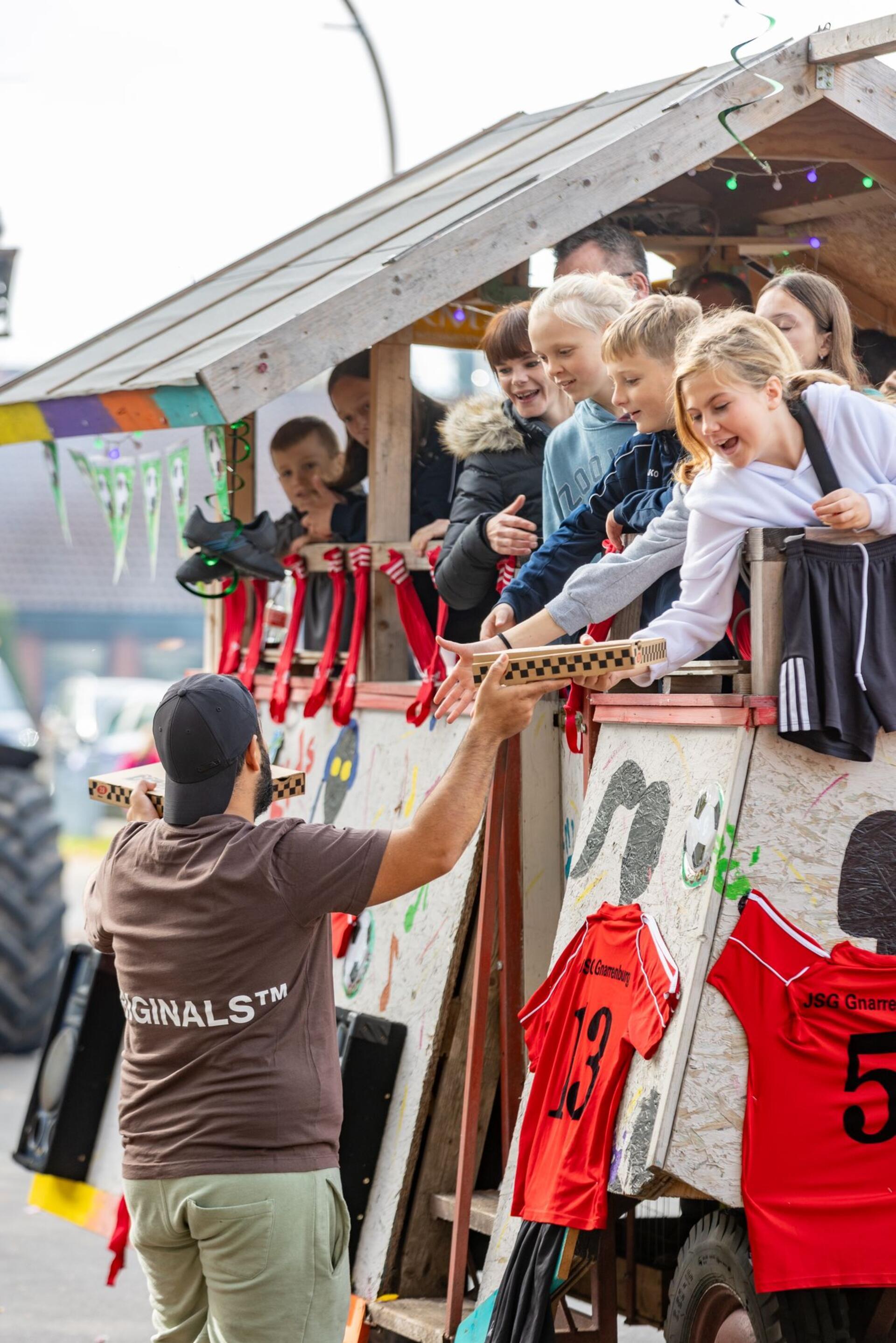 Beste Stimmung auf den Erntewagen in Gnarrenburg: „Tigris Döner“ verteilt seit zehn Jahren über 150 Pizzen an die Teilnehmerinnen und Teilnehmer der WIR-Erntewagen-Parade.