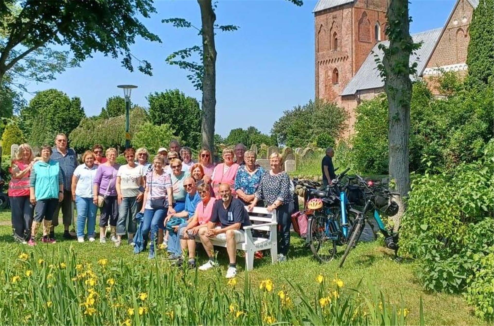 Die Rhader Landfrauen posieren vor einer Kirche. 