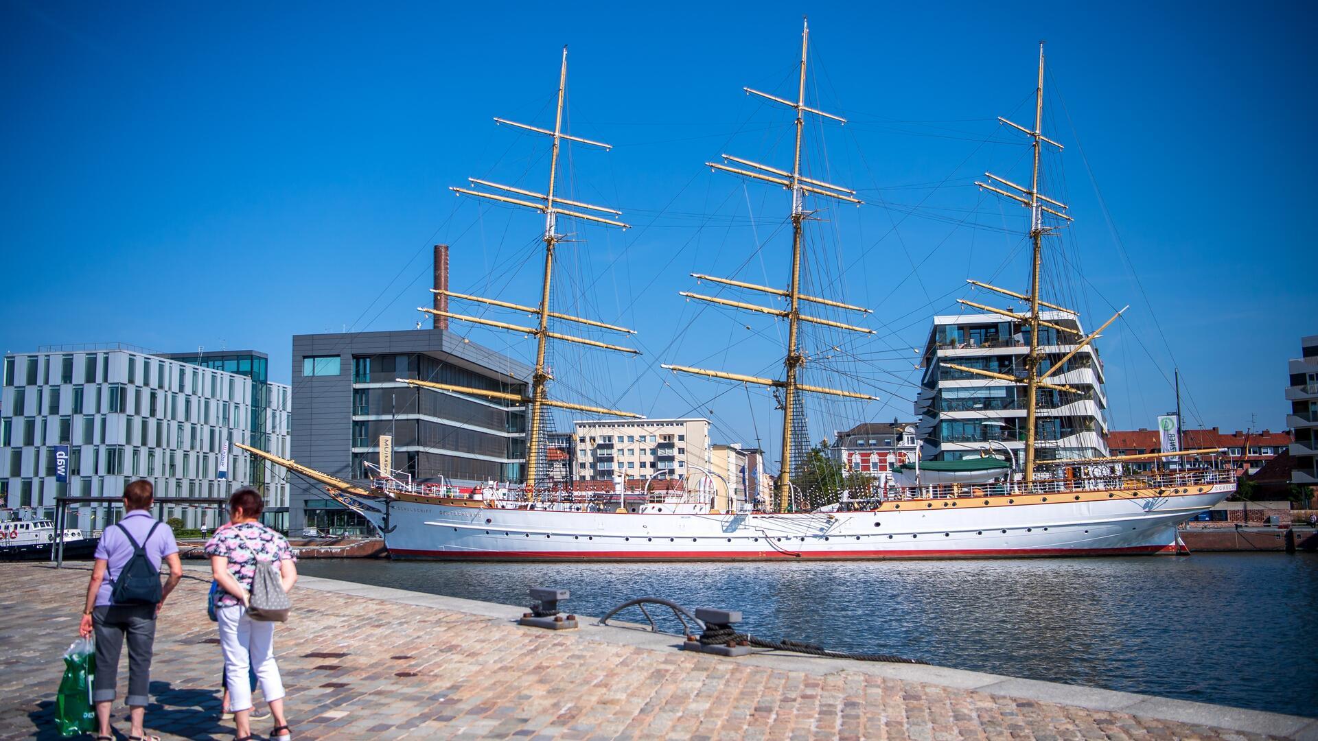 Ein weißes Segelschiff am Hafen.