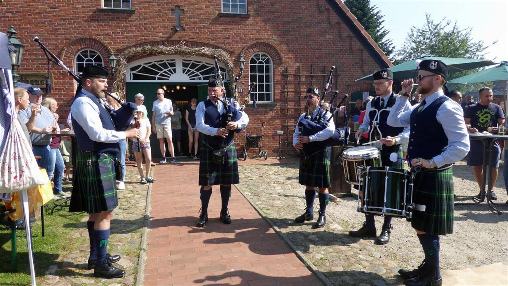 Auftritt des Bremer Dudelsackorchesters „Crest of Gordon“ vor dem Heimathaus Uthlede, umringt von Zuhörern