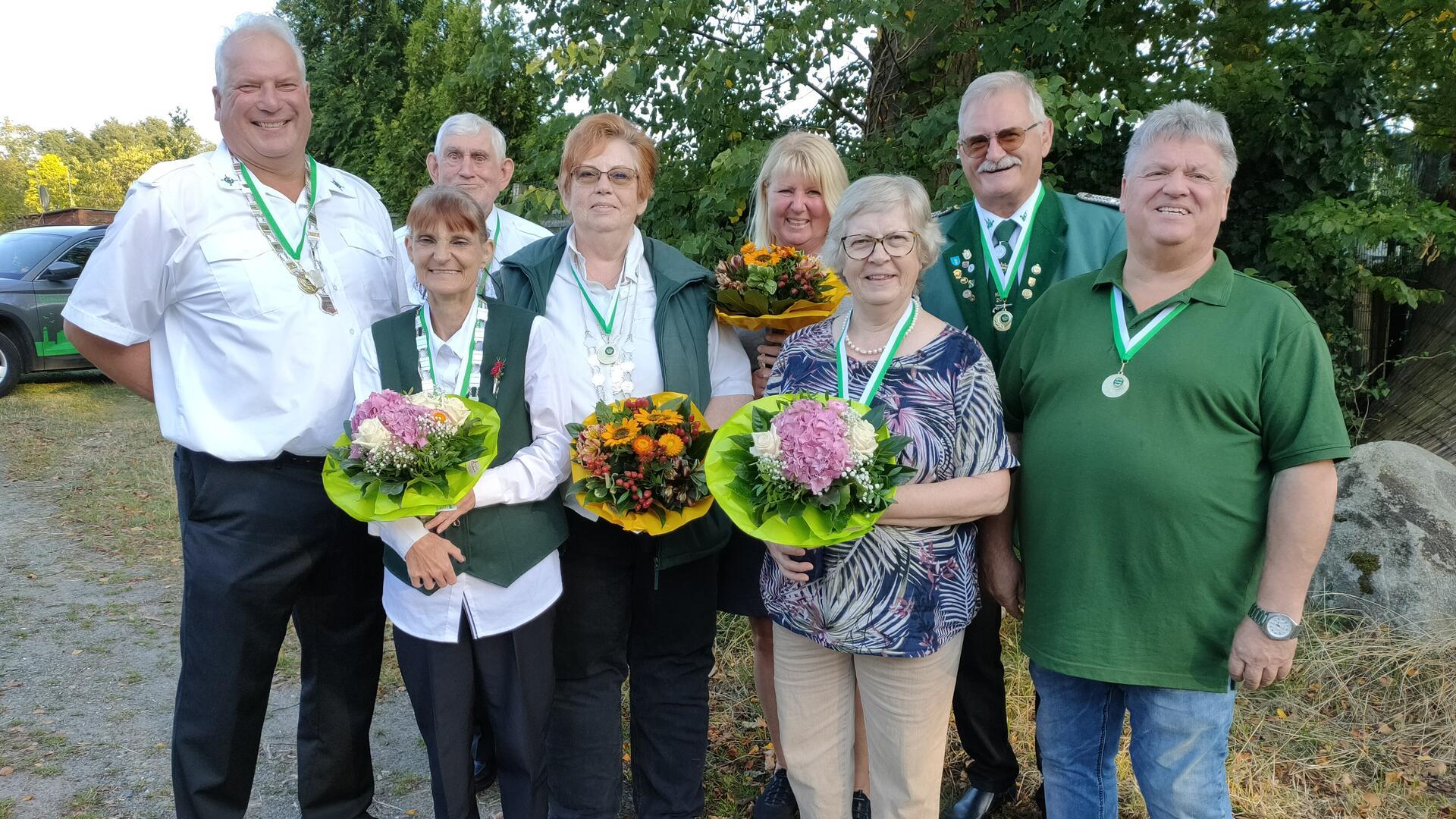 Vier Frauen und vier Männer, teilweise in Schützenuniform, posieren für ein Gruppenfoto.