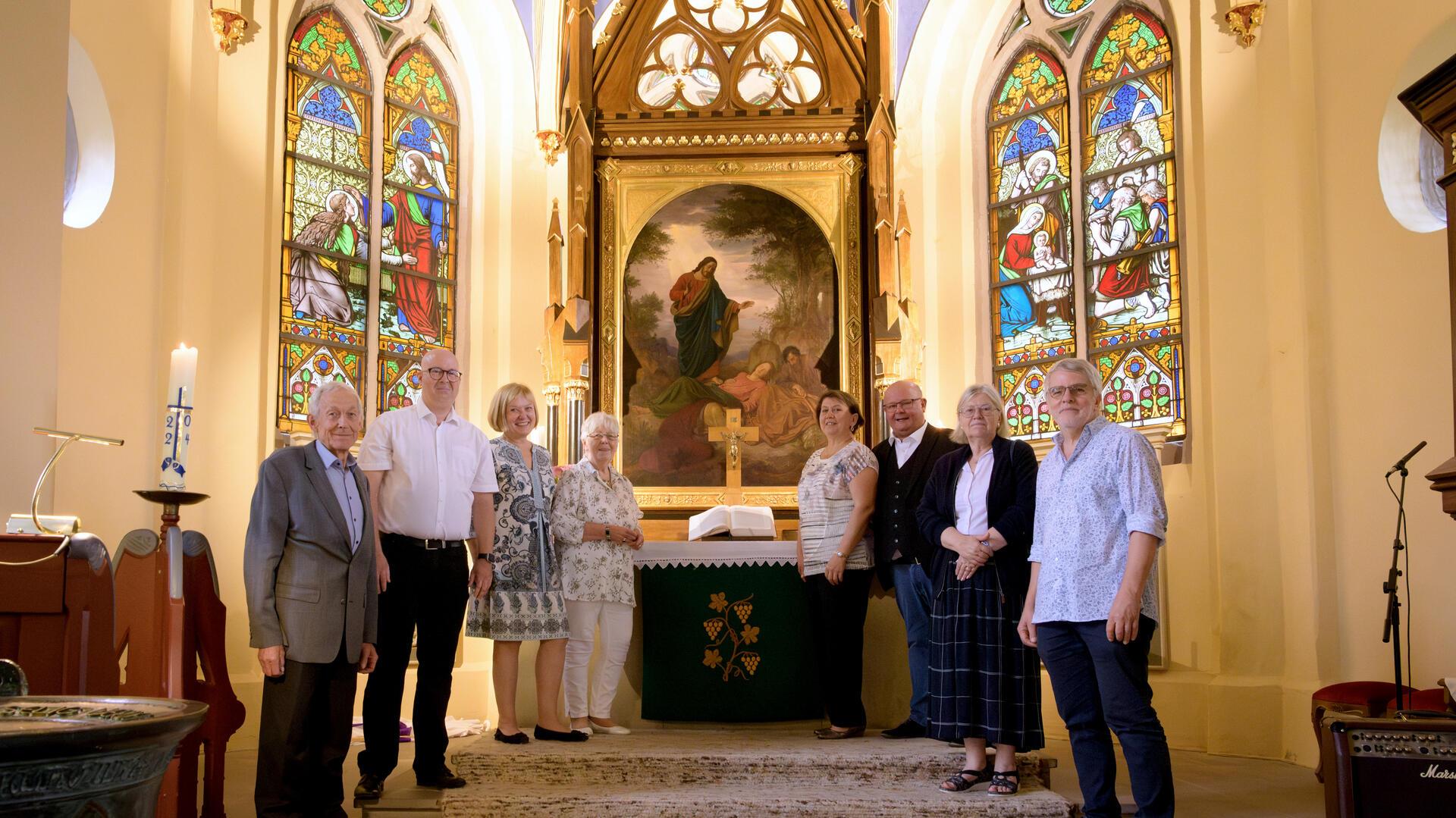 Vor dem restaurierten Altar (von links): Dr. Jan Schilling (Nachfahre Familie Brinkama), Pastor Alexander Wilken, Susanne Wendorf-von Blumröder  (Superintendentin des Kirchenkreises), die Kirchenvorstände Annette Faße, Helena Brandt, Carsten Mund und Gabriele Young sowie der ehemalige Pastor Michael Maschke.