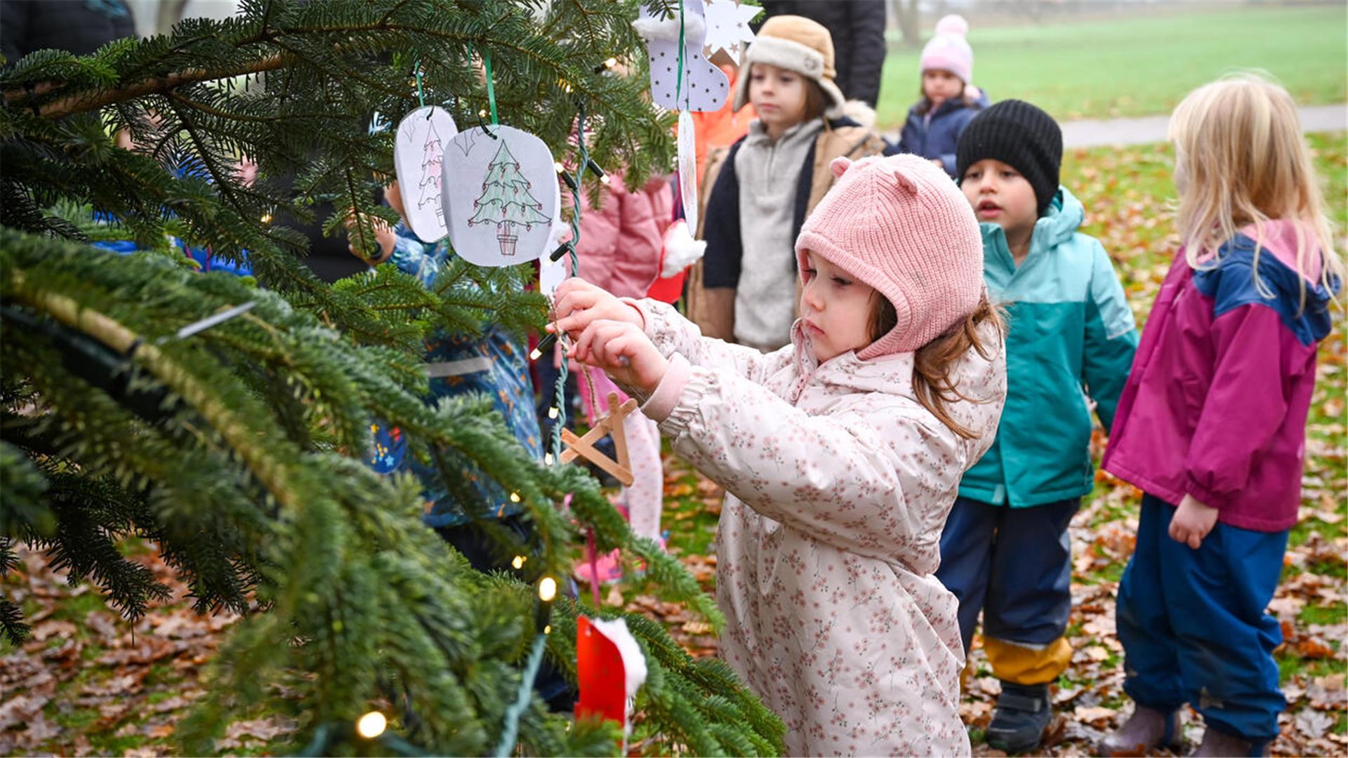 Kinder schmücken einen Tannenbaum