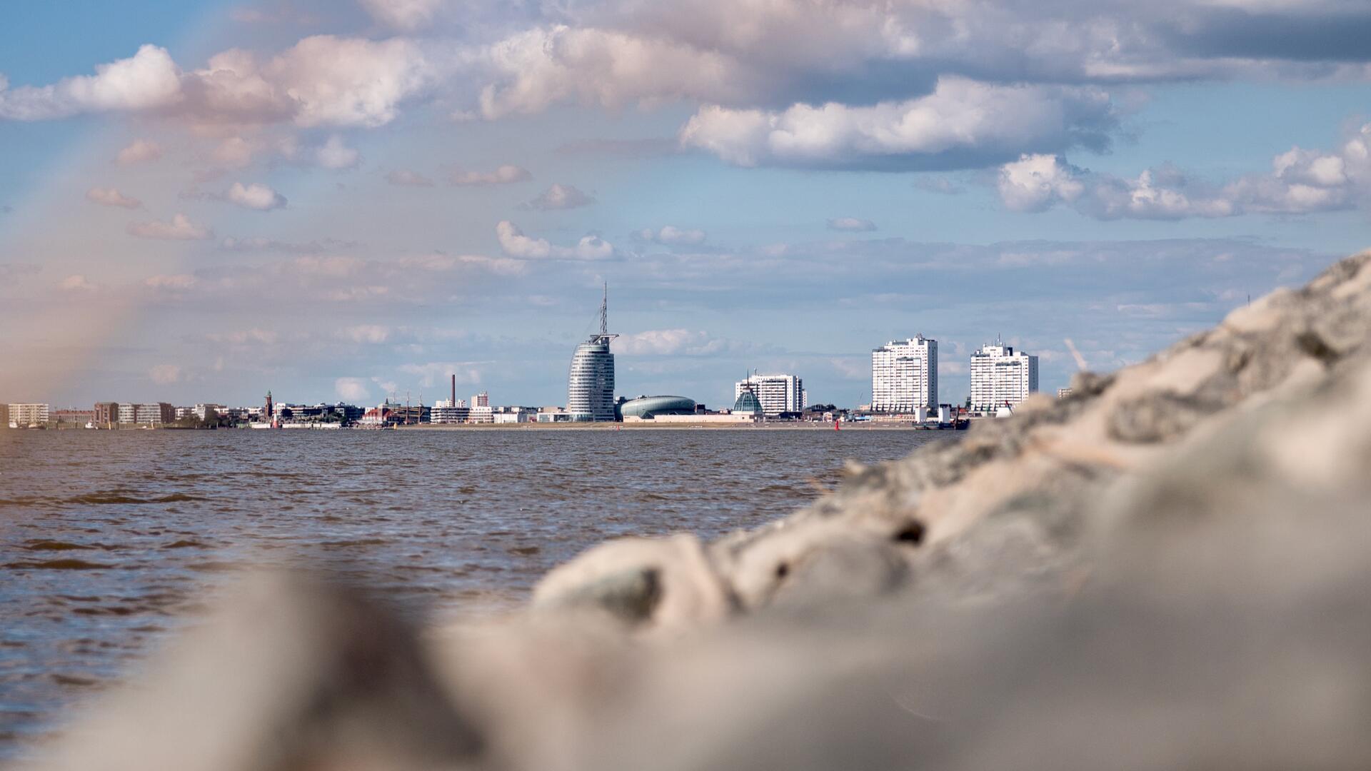 Blick auf die Weser und die Skyline von Bremerhaven mit der Sail City Aussichtsplattform, dem Klimahaus und Apartmentgebäuden.