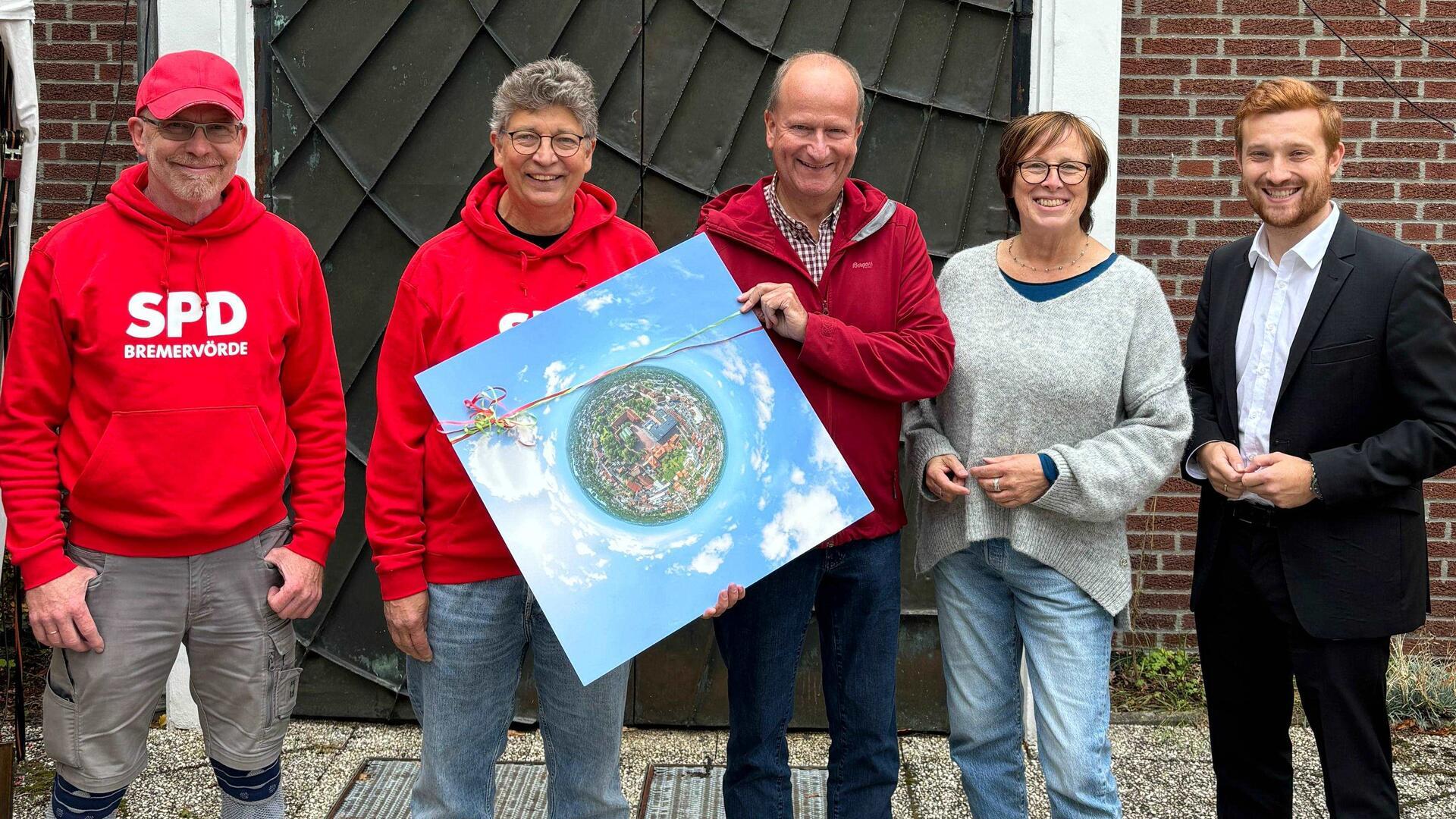 Bremervördes Ortsbürgermeister Dirk-Frederik Stelling (rechts) überreichte ein besonderes Luftbild der Ostestadt an Stadtteilladen-Leiterin Almut Schmidt und Pastor Volker Rosenfeld (Zweite von rechts). Die Sozialdemokraten Lars Lust und Rüdiger Holst zählten beim Jubiläumsfest zu den Gratulanten und Unterstützern.