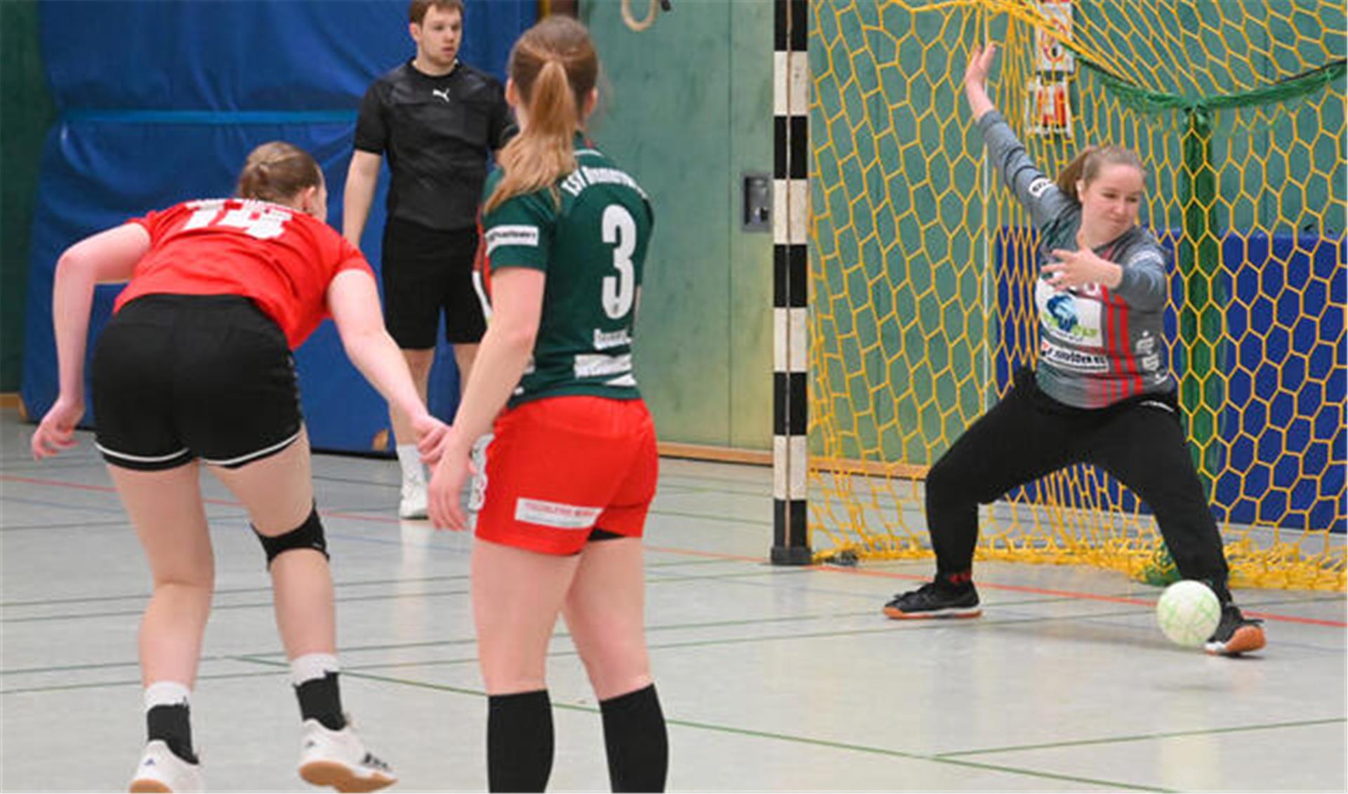 Handballtorhüterin wehrt Ball mit dem Fuß ab