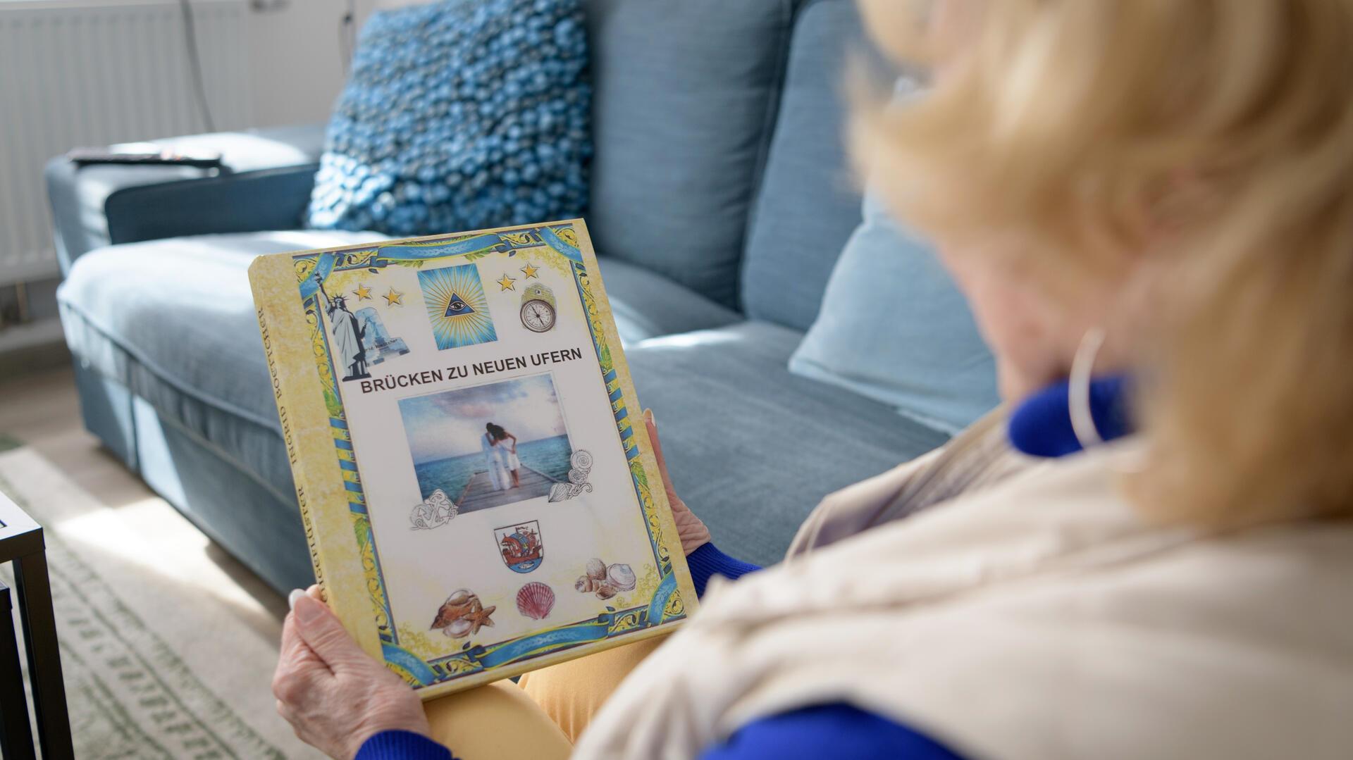 Eine Frau hält ein Fotobuch in der Hand.