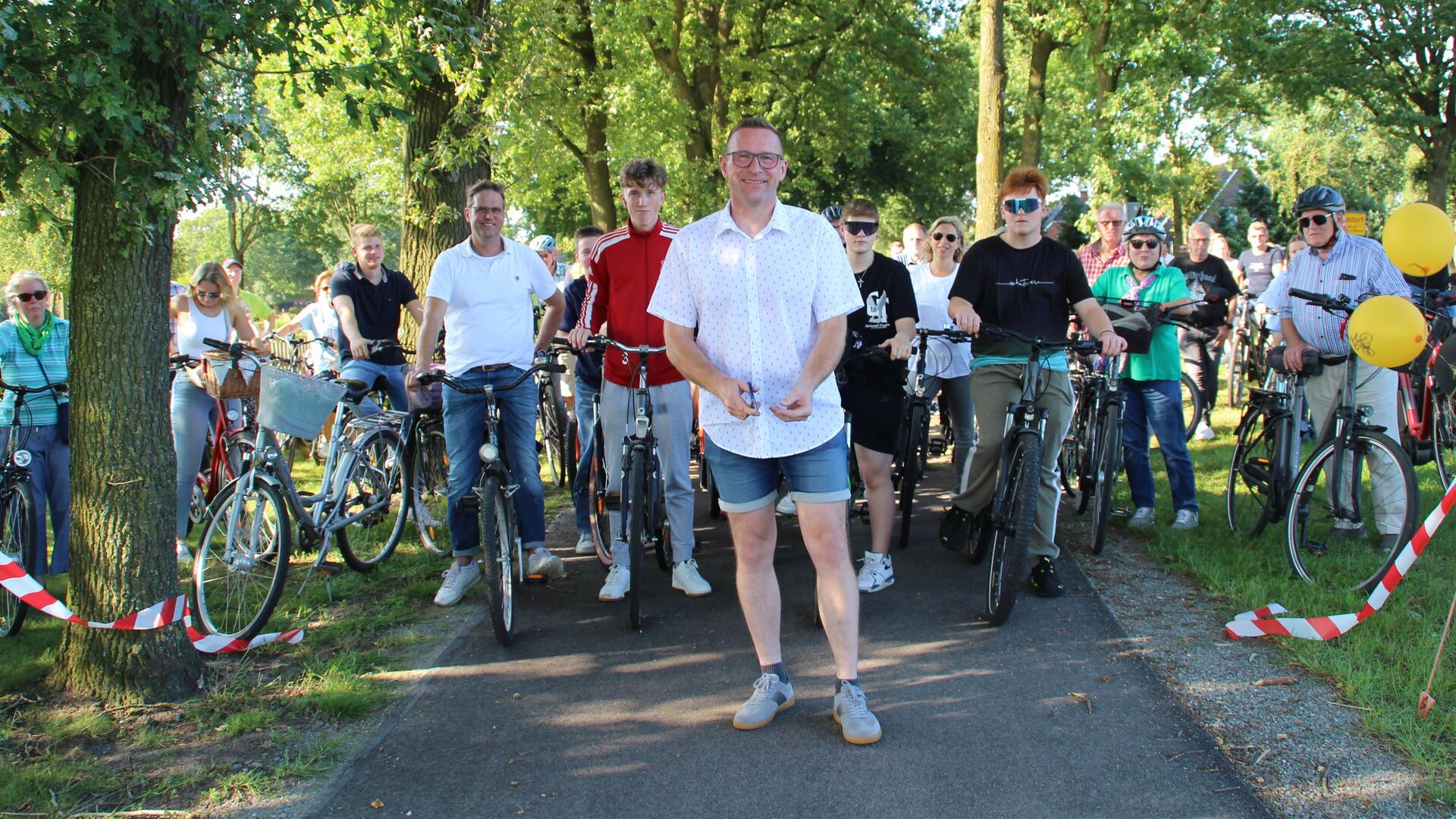 Bürgermeister Harald Hauschild durchschneidet symbolisch ein Band, um den Fahrradweg zwischen Seedorf und Godenstedt offiziell einzuweihen. 