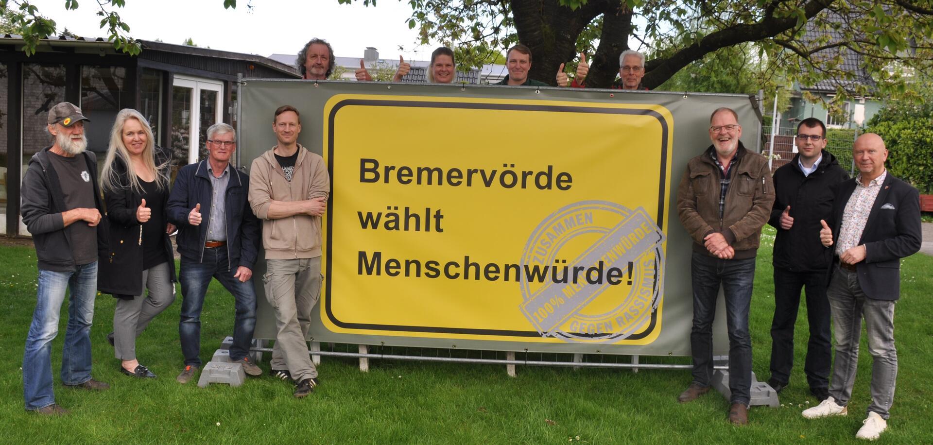 Bürgermeister und Ortsvorsteher der Stadt Bremervörde sowie Aktive des Bündnisses für Demokratie und Menschenwürde stellen das Banner vor, das ab nächsten Dienstag in jeder der zwölf Bremervörder Ortschaften stehen wird.