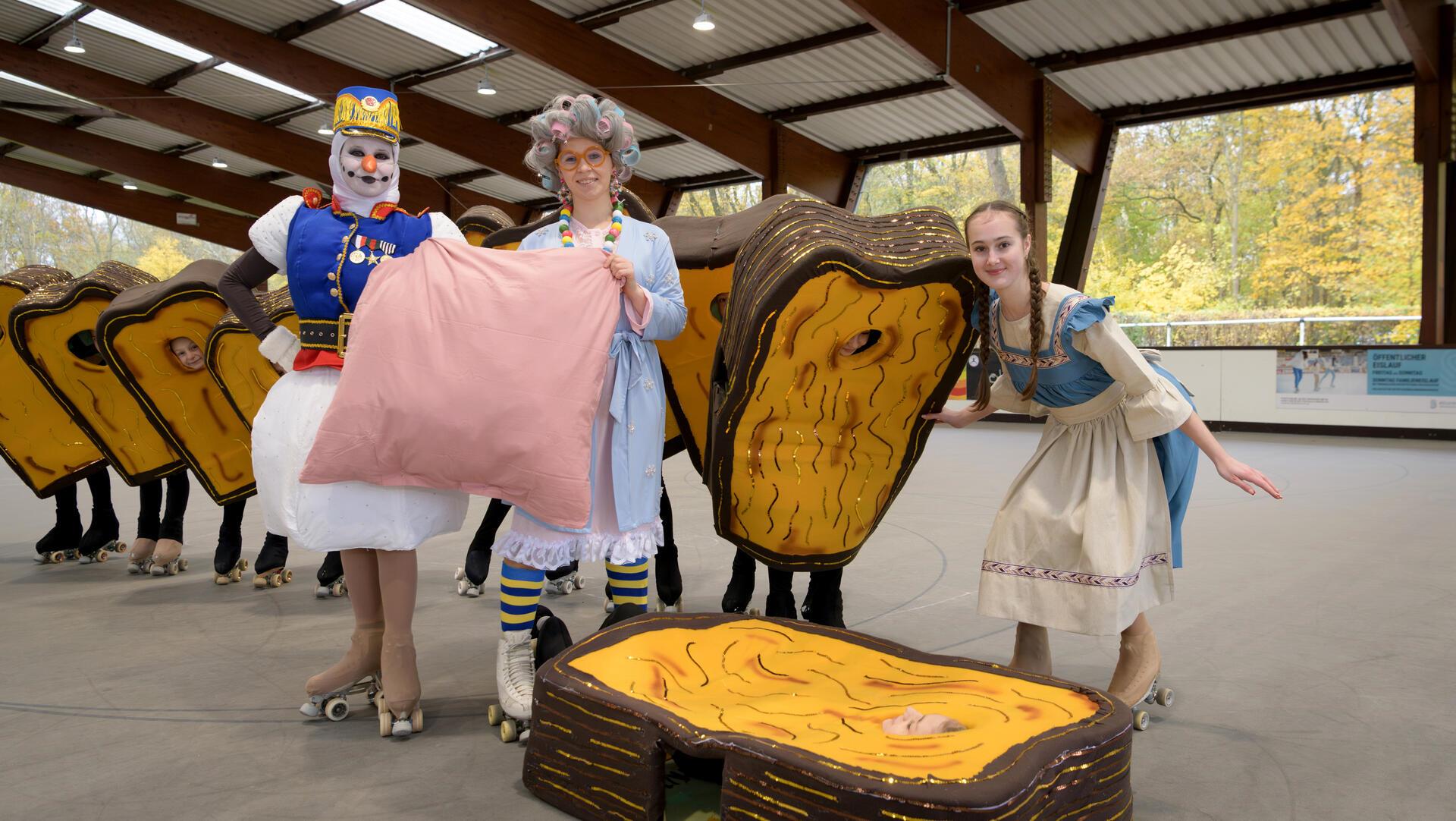 Buntes Treiben auf der Rollschuhbahn: Schneemann, Frau Holle und Goldmarie (von links) posieren mit einem Toastbrot.
