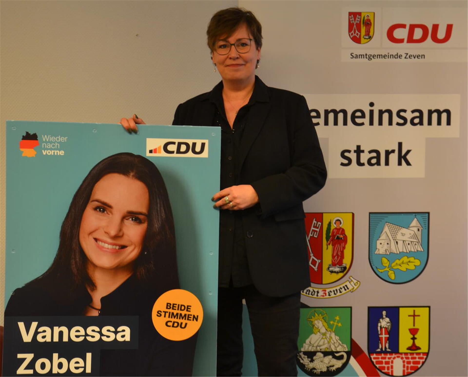 CDU-Gemeindeverbandsvorsitzende Kersten Dettmer mit dem Wahlplakat von Wahlkreiskandidatin Vanessa Zobel.