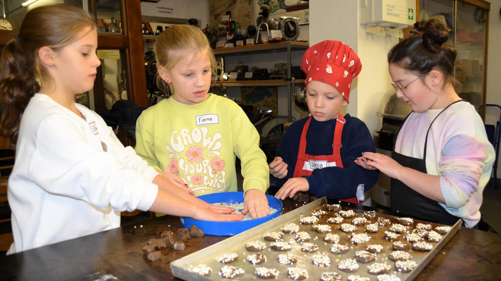 Charlotte, Fiene, Jakob und Noeli (von links) backen Plätzchen.