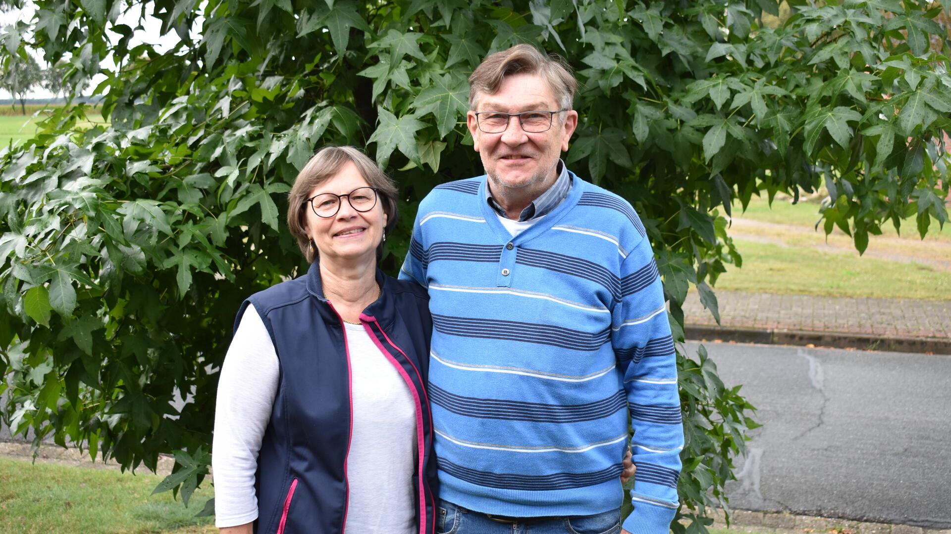 Ein Mann und eine Frau stehen vor einem Baum.