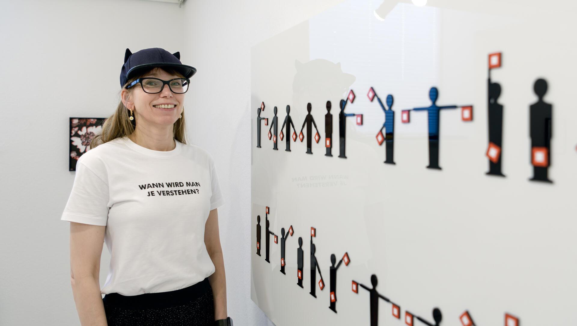 Claudia Christoffel ist von Marlene Dietrichs Engagement fasziniert. So sang der Star die Antikriegshymne „Sag mir, wo die Blumen sind“. Die Liedzeile „Wann wird man je verstehen“ gibt der Ausstellung den Titel. Und sie steht auch auf dem T-Shirt, das die Künstlerin trägt. Und wer die Zeichen des Winkelalphabets beherrscht, kann sie auch an der Wand lesen.