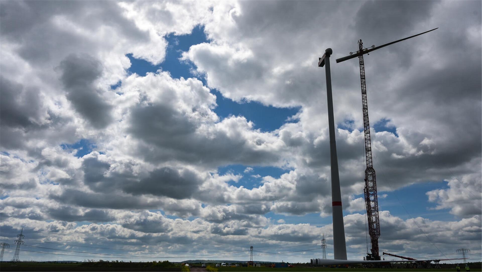 Zur Montage an einem Windrad im Energiepark Bad Lauchstädt wird ein Rotorblatt mit einem Kran in die Höhe gehoben.