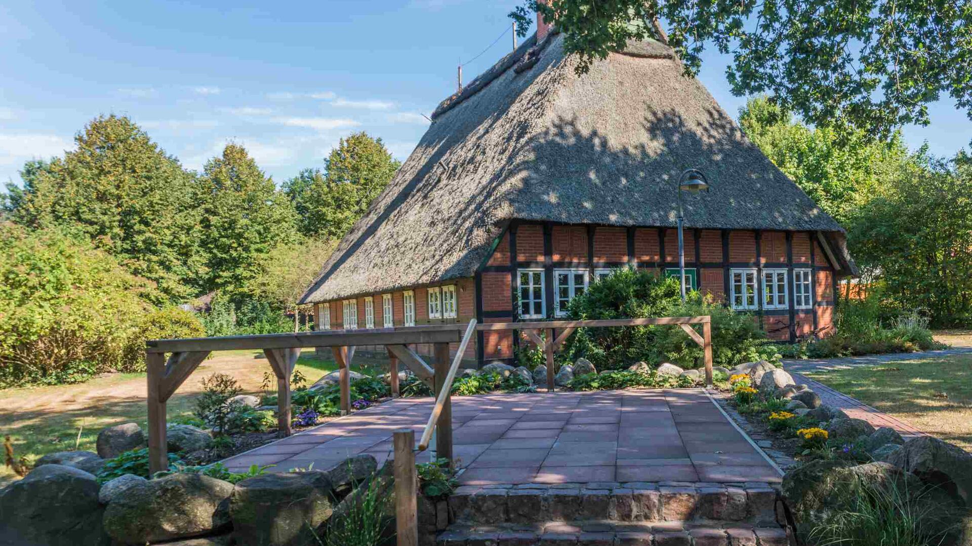 Hokemeyers Hus im Hintergrund, eine gepflasterte Bühne im Vordergrund