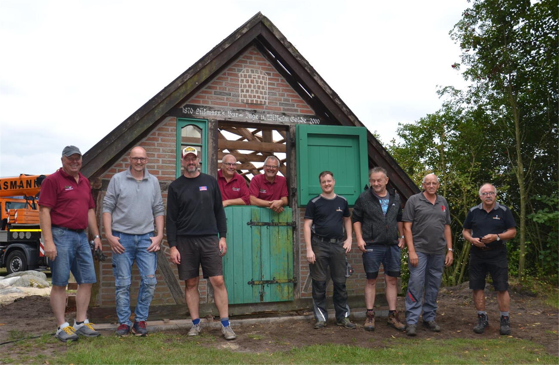 Neun Männer stehen in Volkensen am Backhaus.