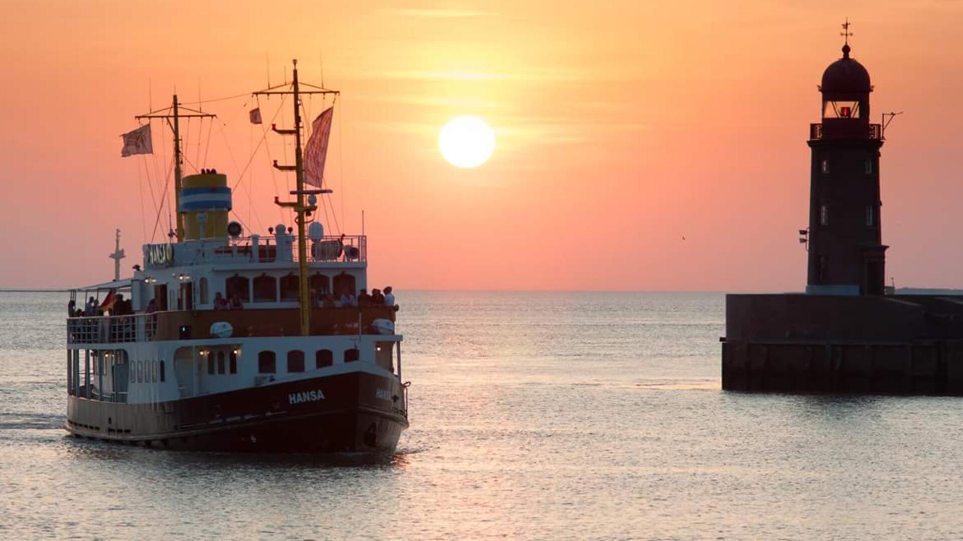 Das Bild ist Geschichte: Die „Hansa“ passiert im Sonnenuntergang die Moleneinfahrt. Die 2022 havarierte Nordmole ist inzwischen abgerissen.