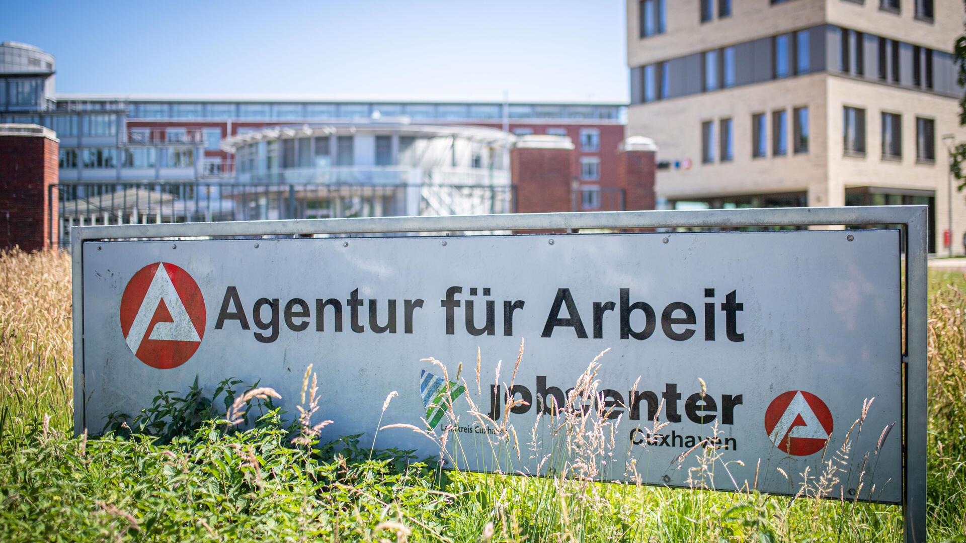 Schild mit Jobcenter-Aufschrift vor Gebäude