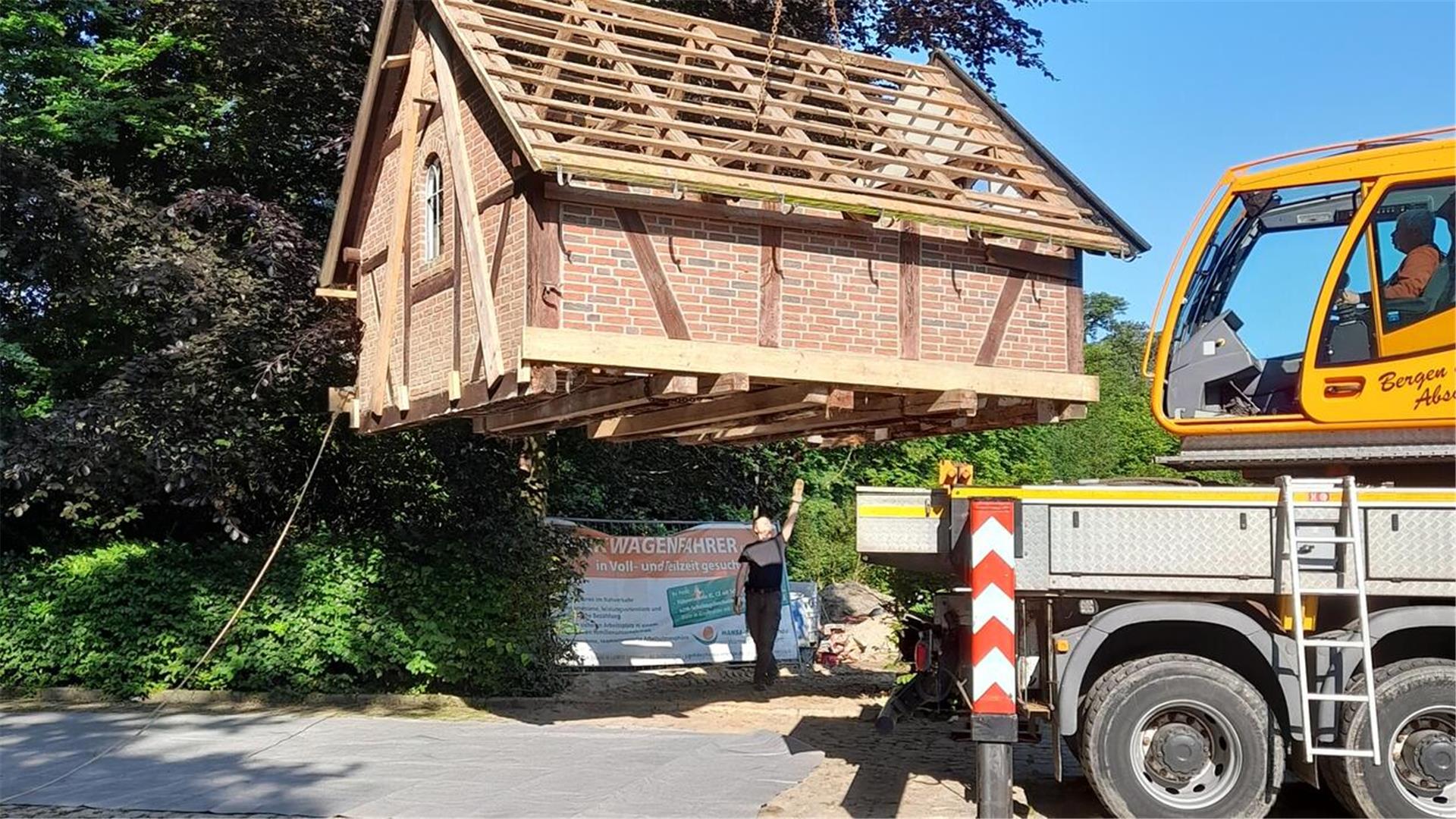 Ein Backhaus hängt am Haken eines Krans.