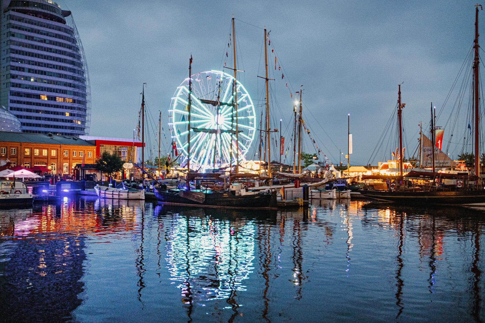 Ein Hafen mit Riesenrad im Hintergrund. 