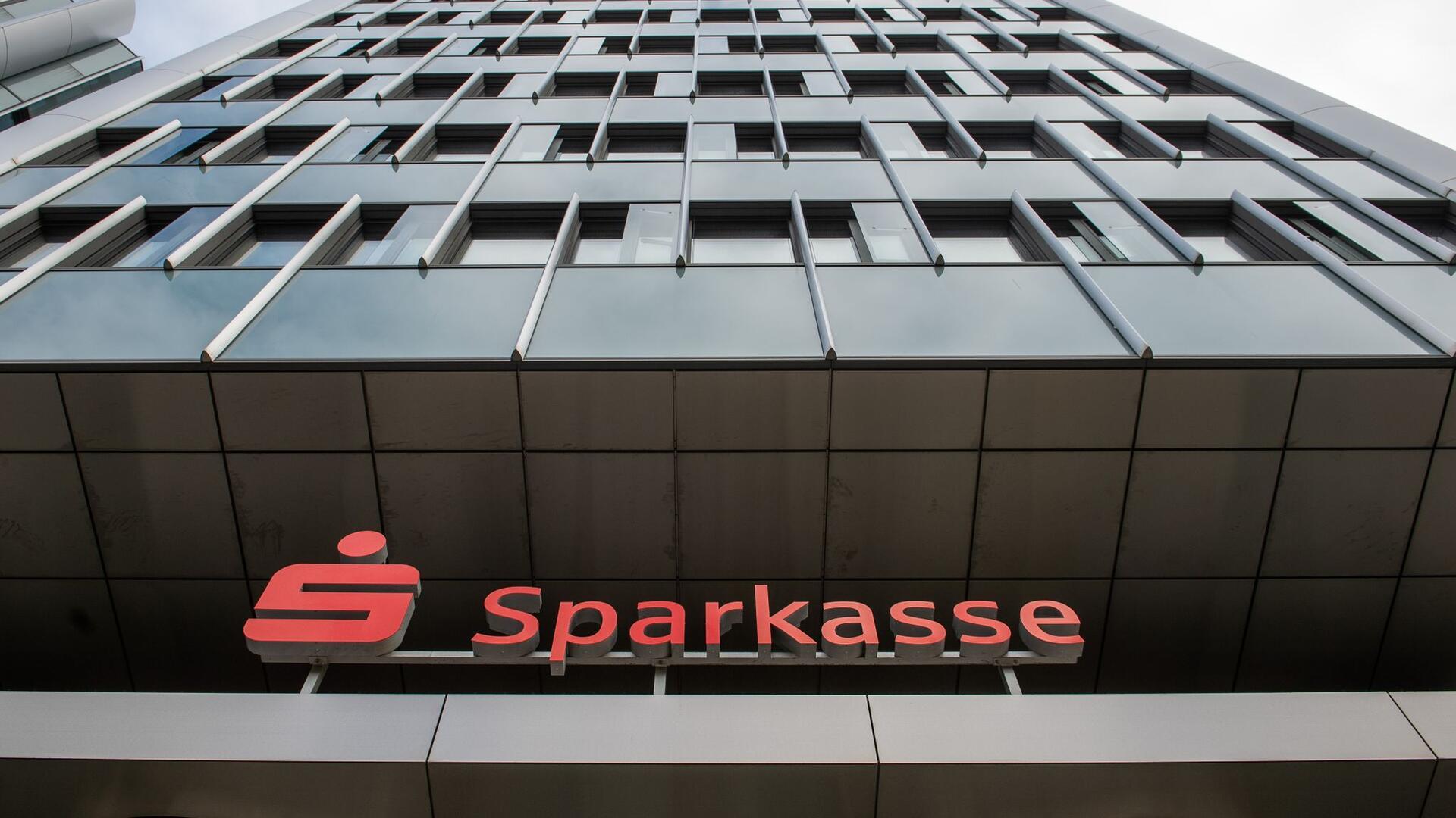 Das Logo der Sparkasse über einem Eingang zum Unternehmenssitz der Sparkasse Hannover.