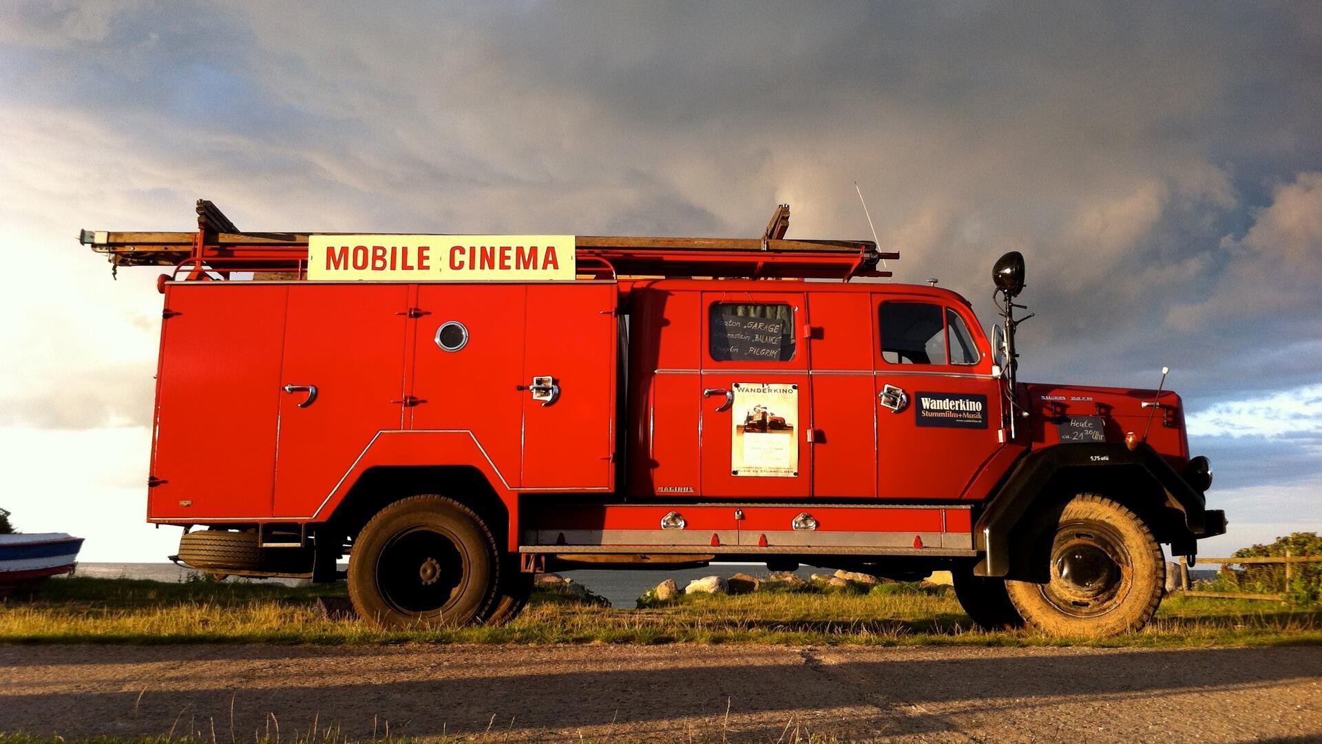 Ein rotes Feuerwehrauto auf dem "Wanderkino" steht.